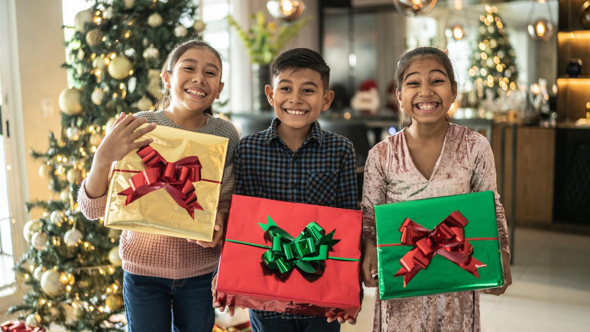 children holding Christmas gifts.