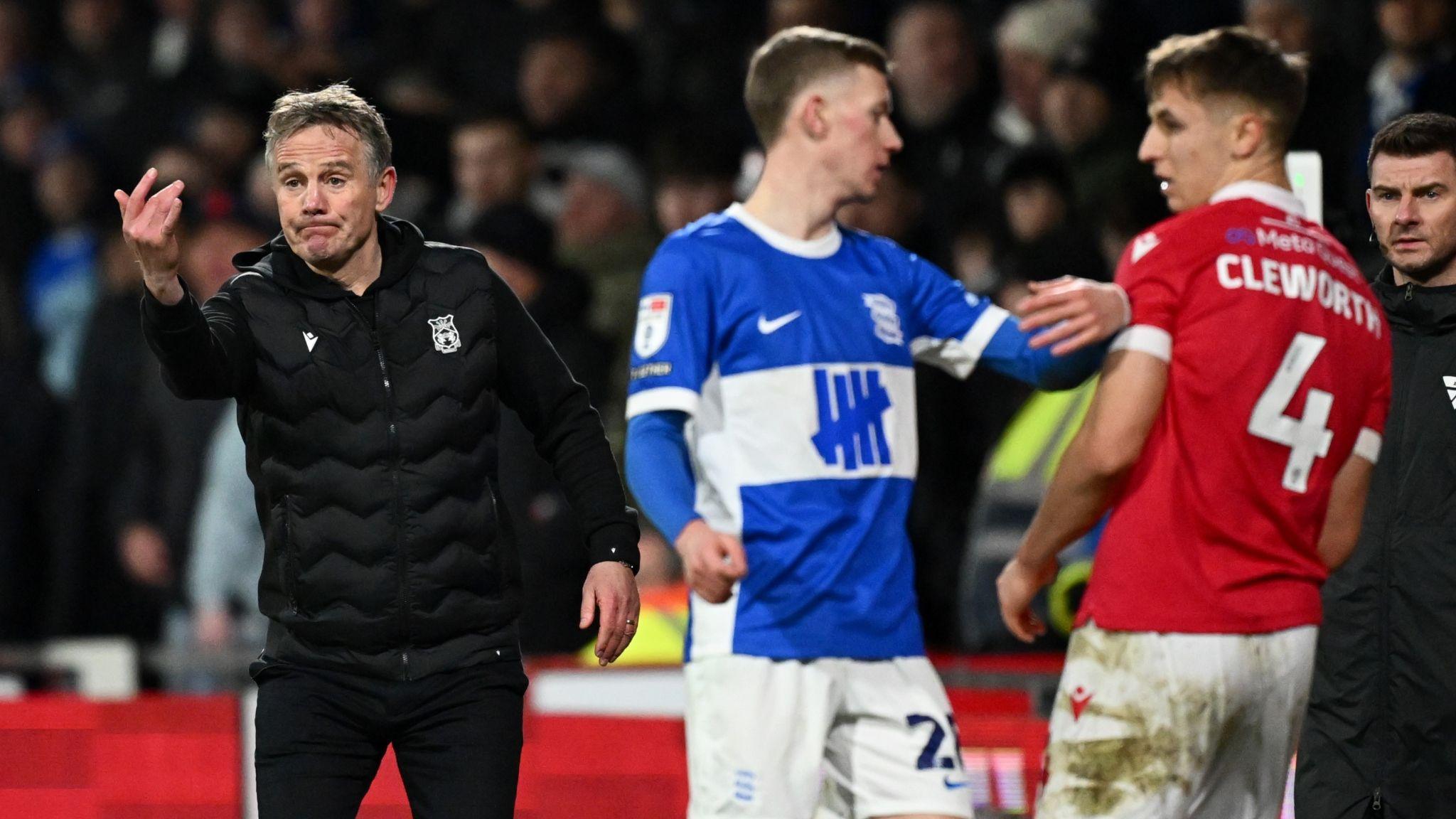 Phil Parkinson gestures on the touchline alongside Birmingham and Wrexham players