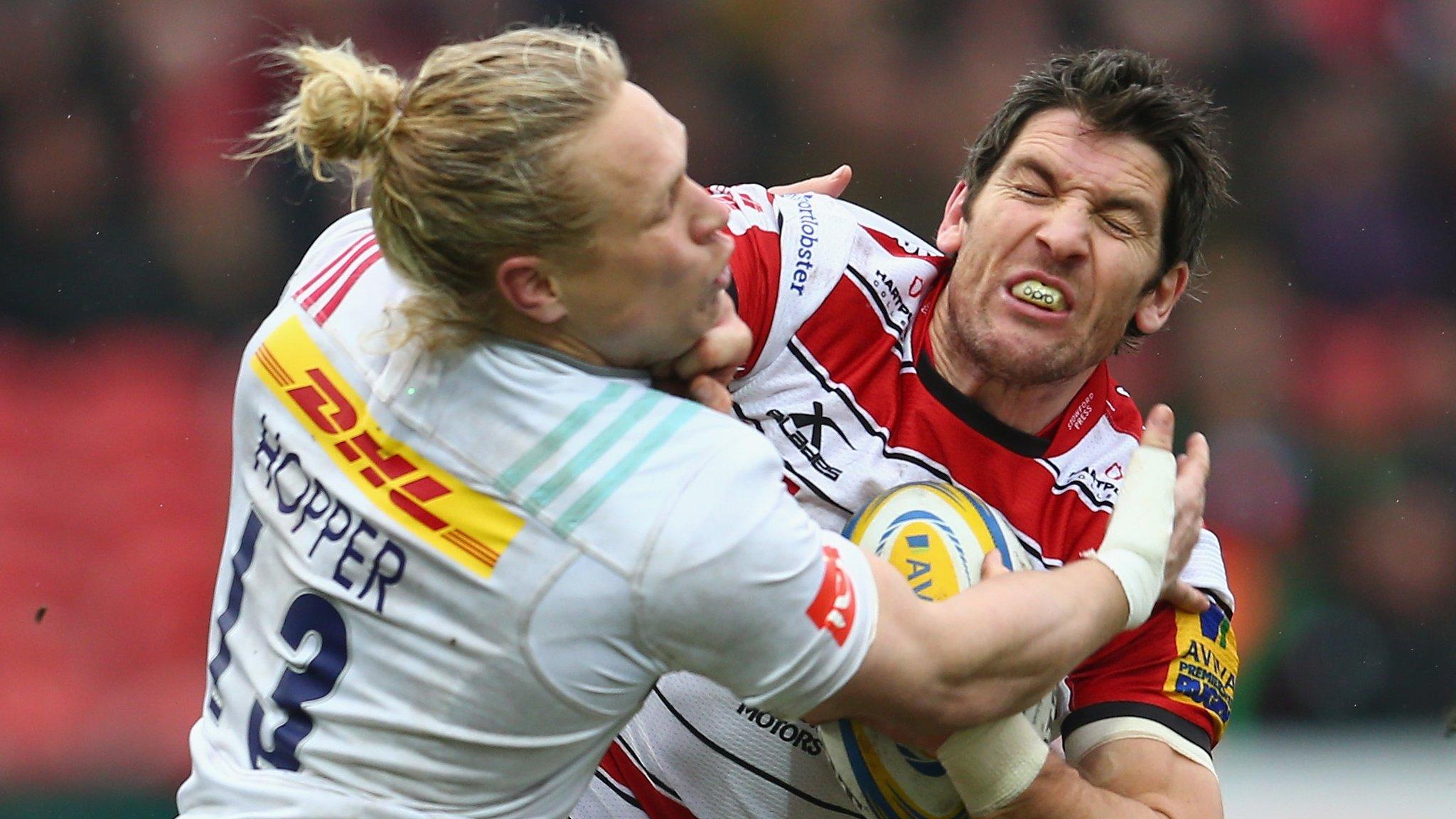 James Hook of Gloucester gets away from a tackle by Matt Hopper of Quins