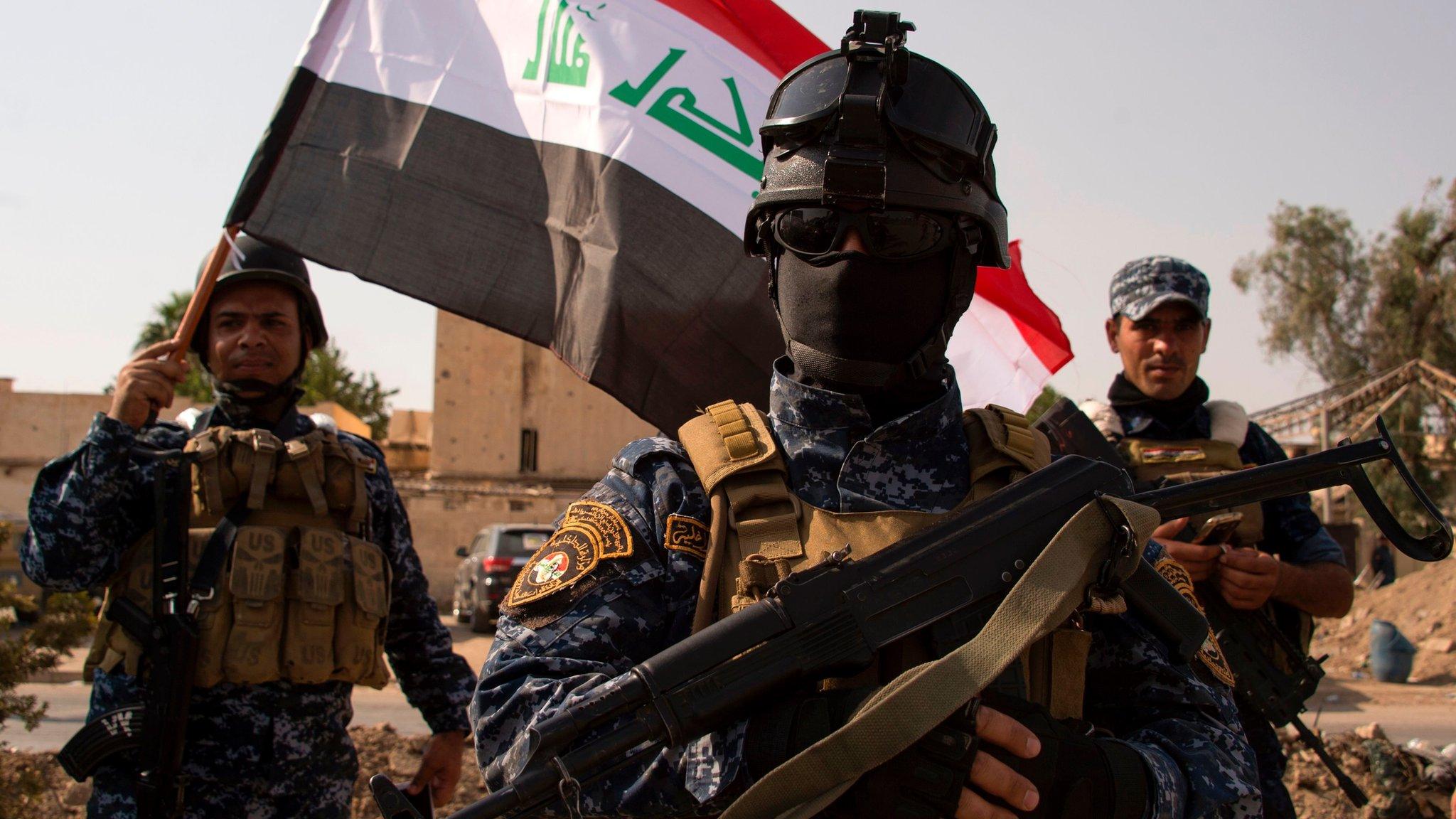 Iraqi federal police officers wave a national flag as they celebrate in Mosul's Old City on 9 July 2017