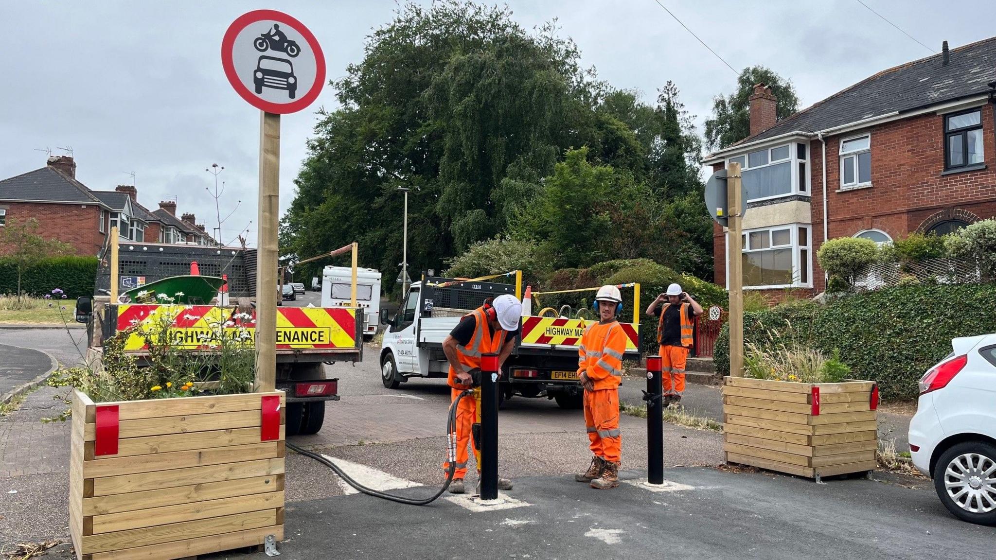 Workmen removing a bollard as partof the Exeter low traffic neighbourhood