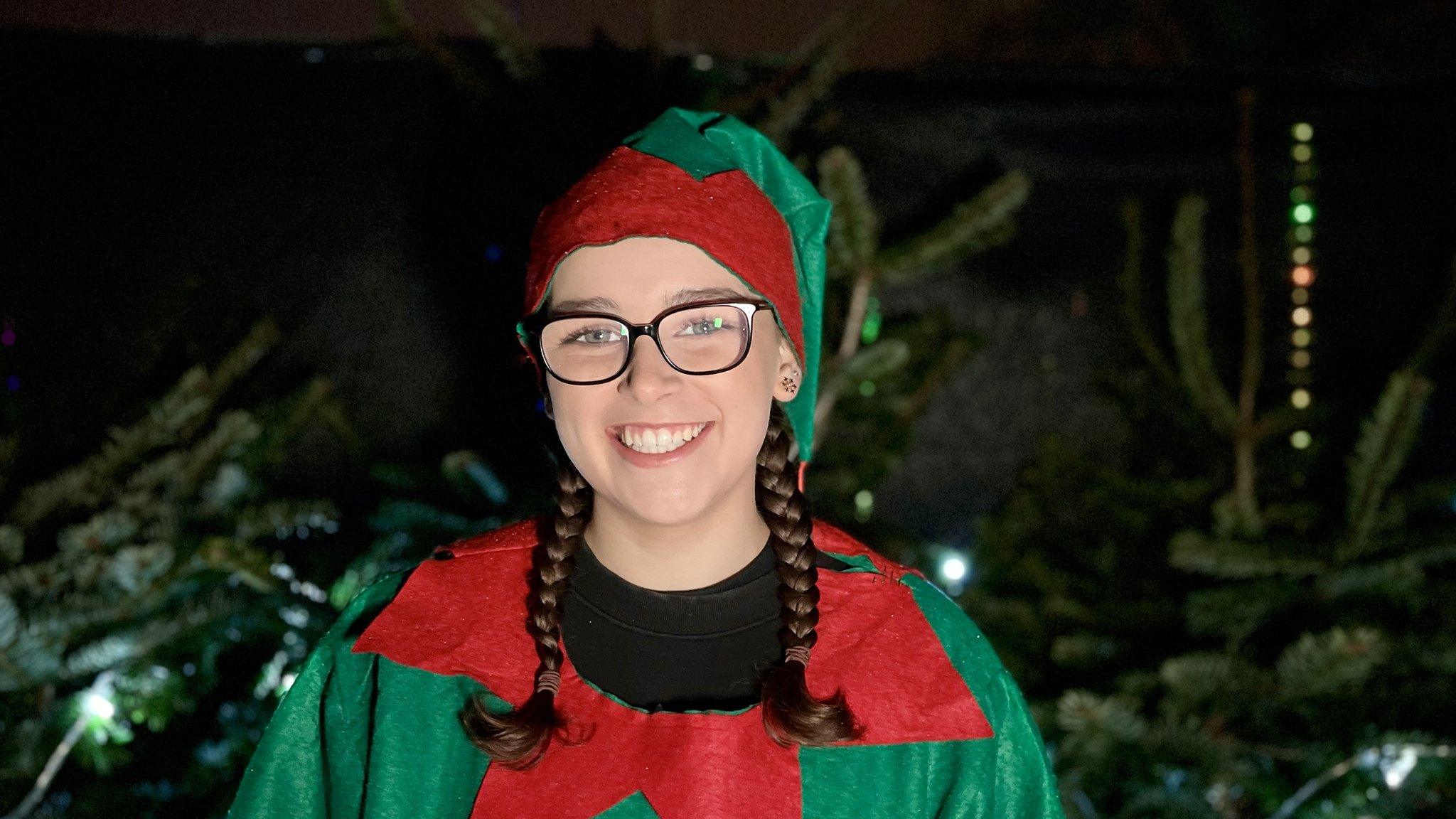 elf in front of christmas trees