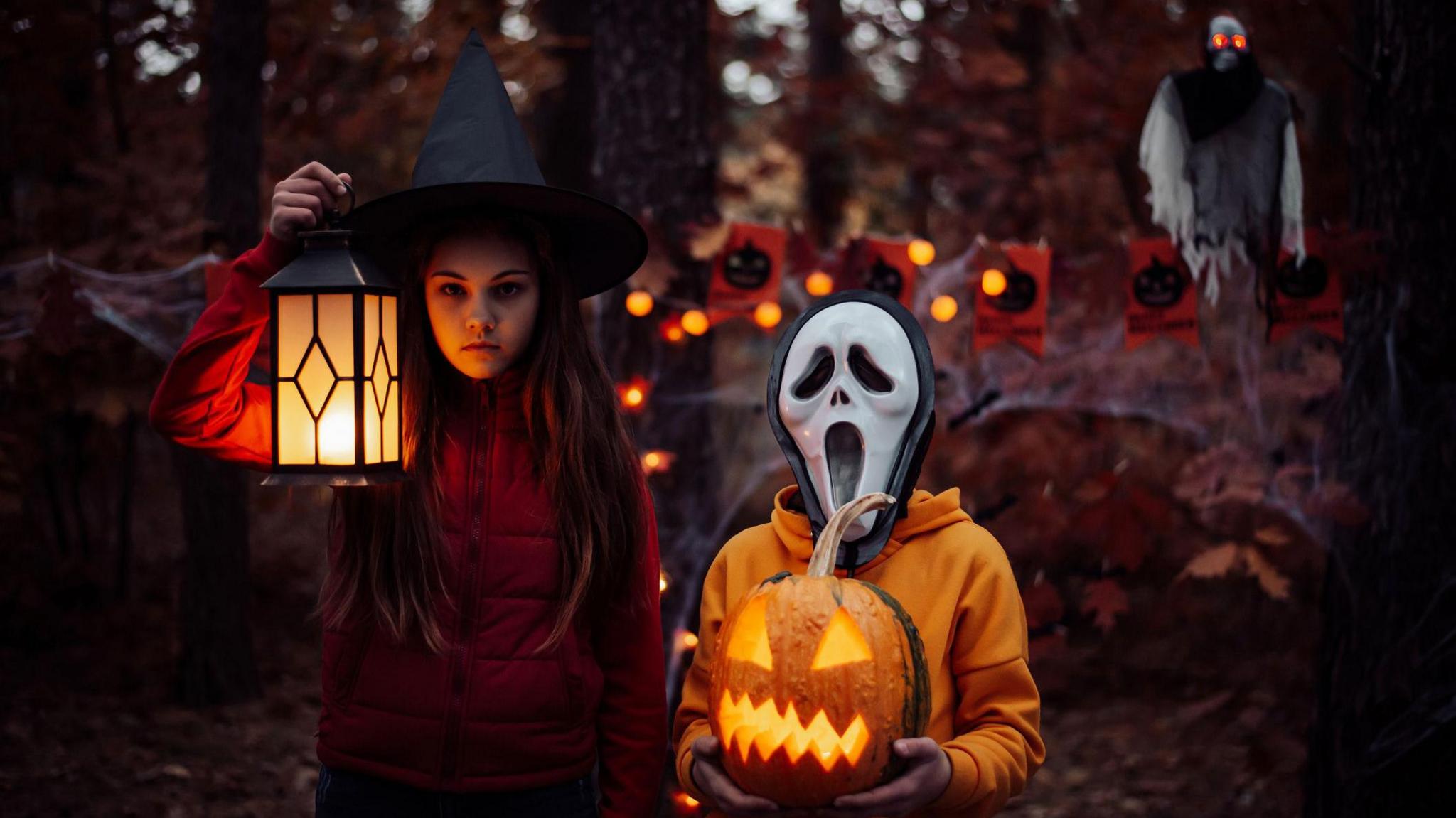 Two children in halloween costumes in the woods