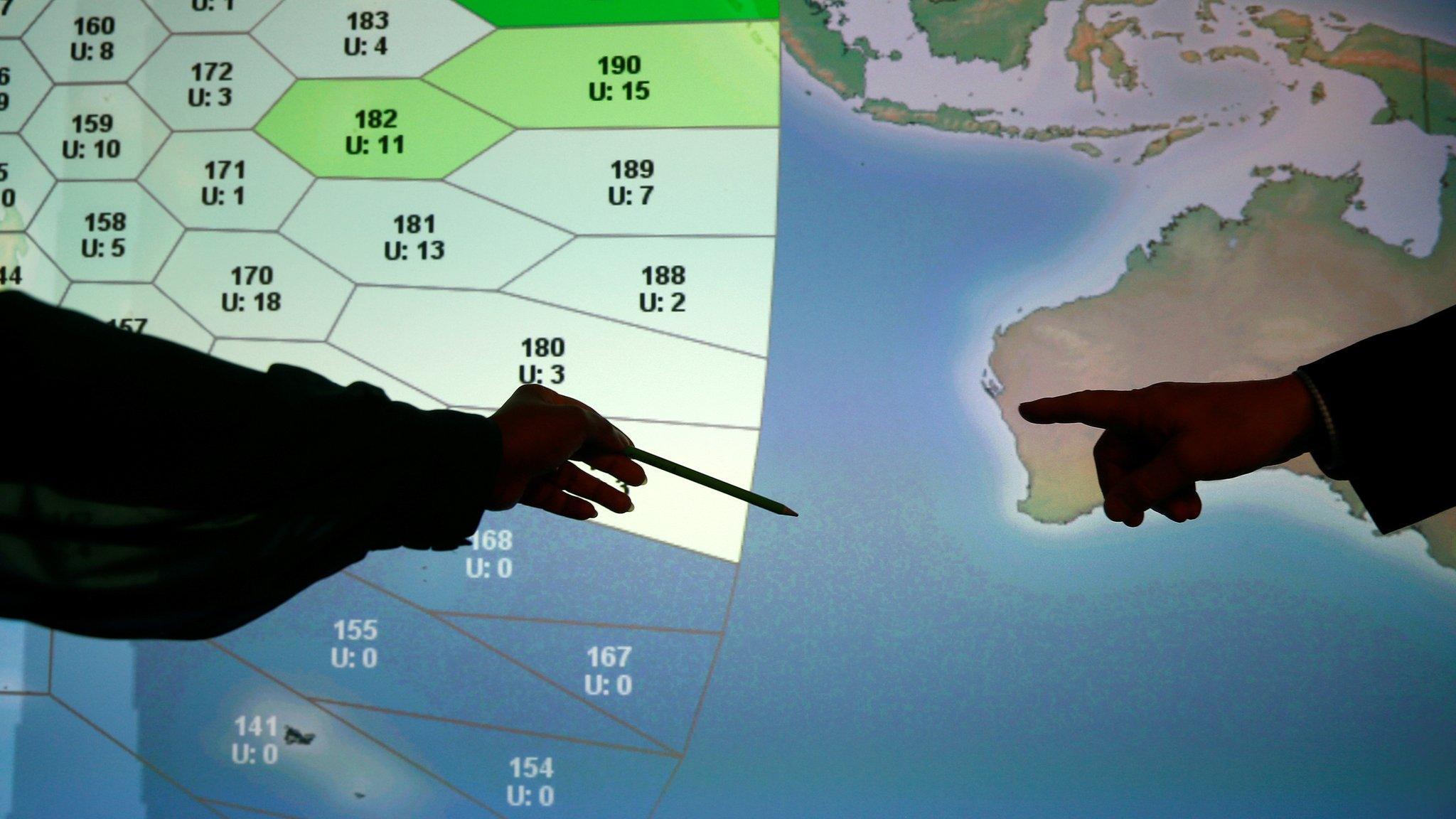 Member of staff at satellite communications company Inmarsat point to a section of the screen showing the southern Indian Ocean to the west of Australia, at their headquarters in London, Britain, March 25, 2014