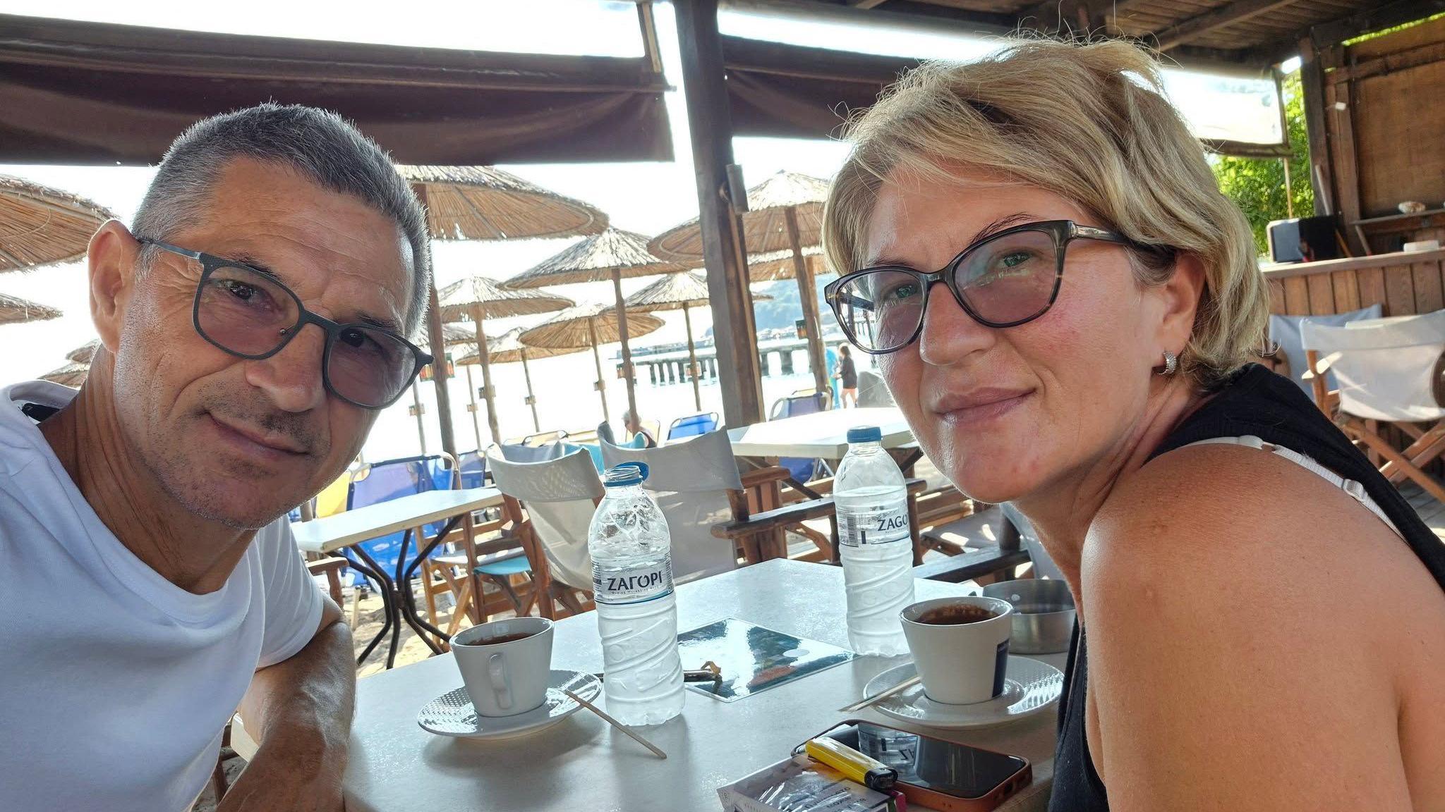 Karovic Ljubisa and his wife Svetlana Grković, smiling for a photo in a bar which appears to be at a holiday resort 