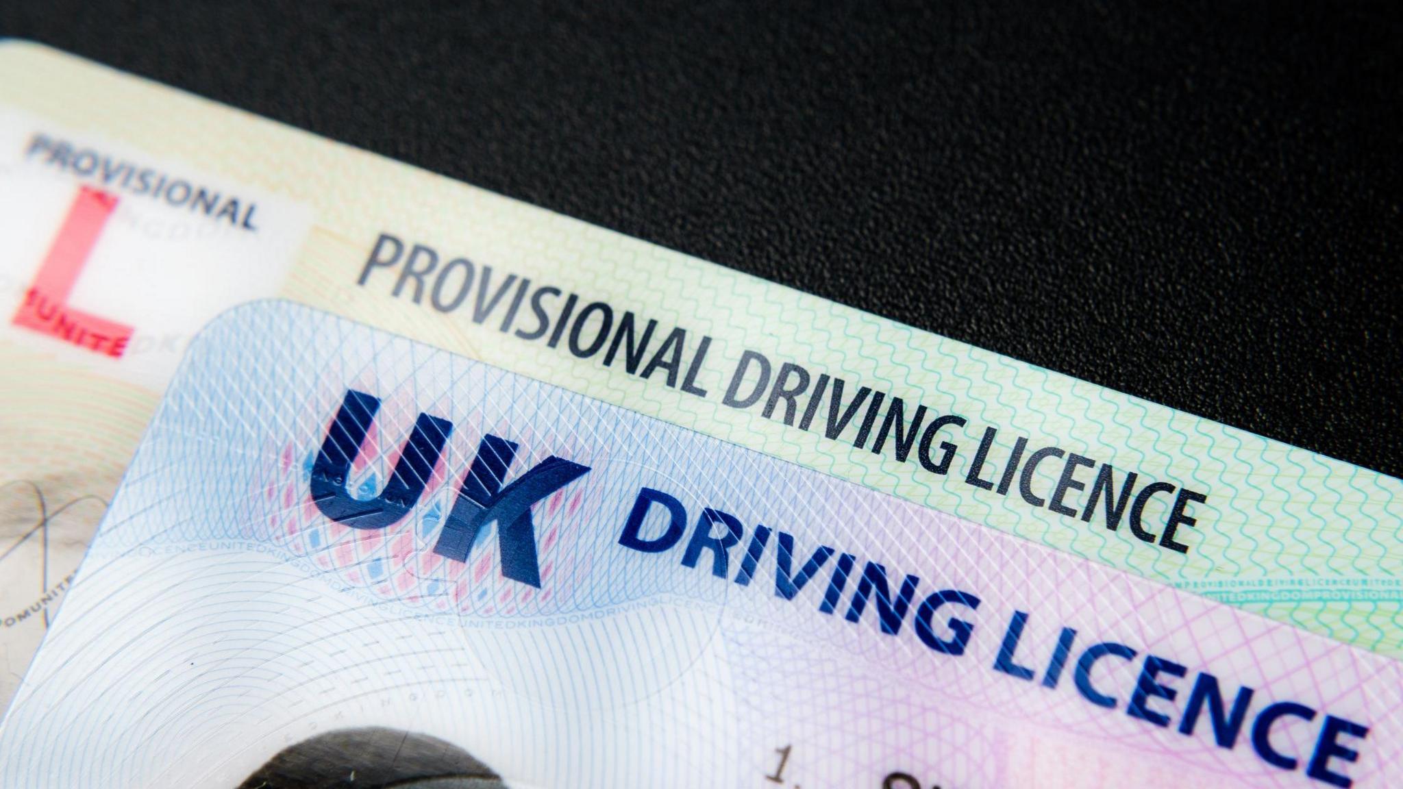 Close-up shot of a full UK driving licence layered on top of a provisional driving licence.