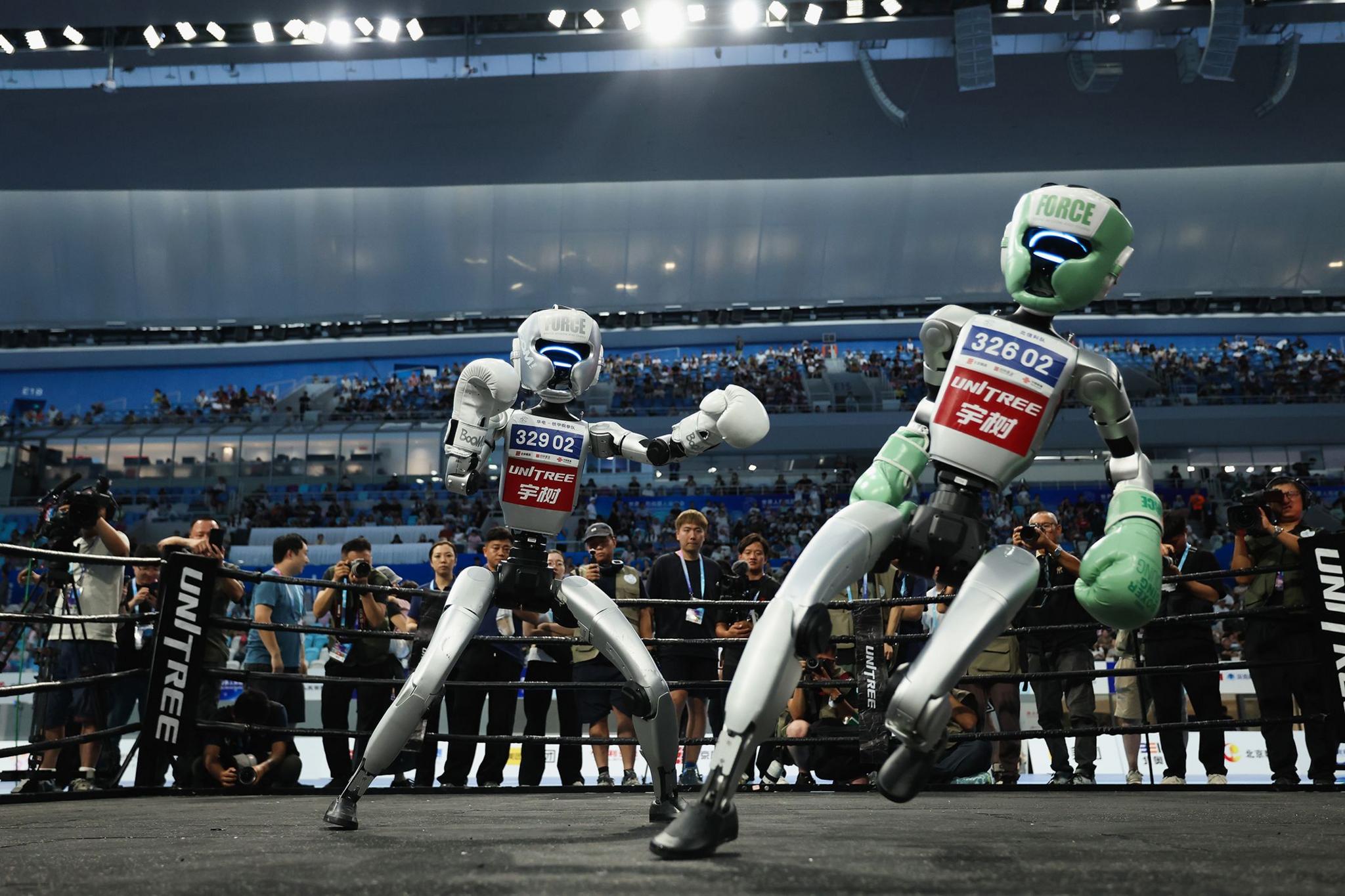 Humanoid robots fight during a kickboxing match on day two of the 2025 World Humanoid Robot Games at National Speed Skating Oval in Beijing, China. Photo by Lintao Zhang