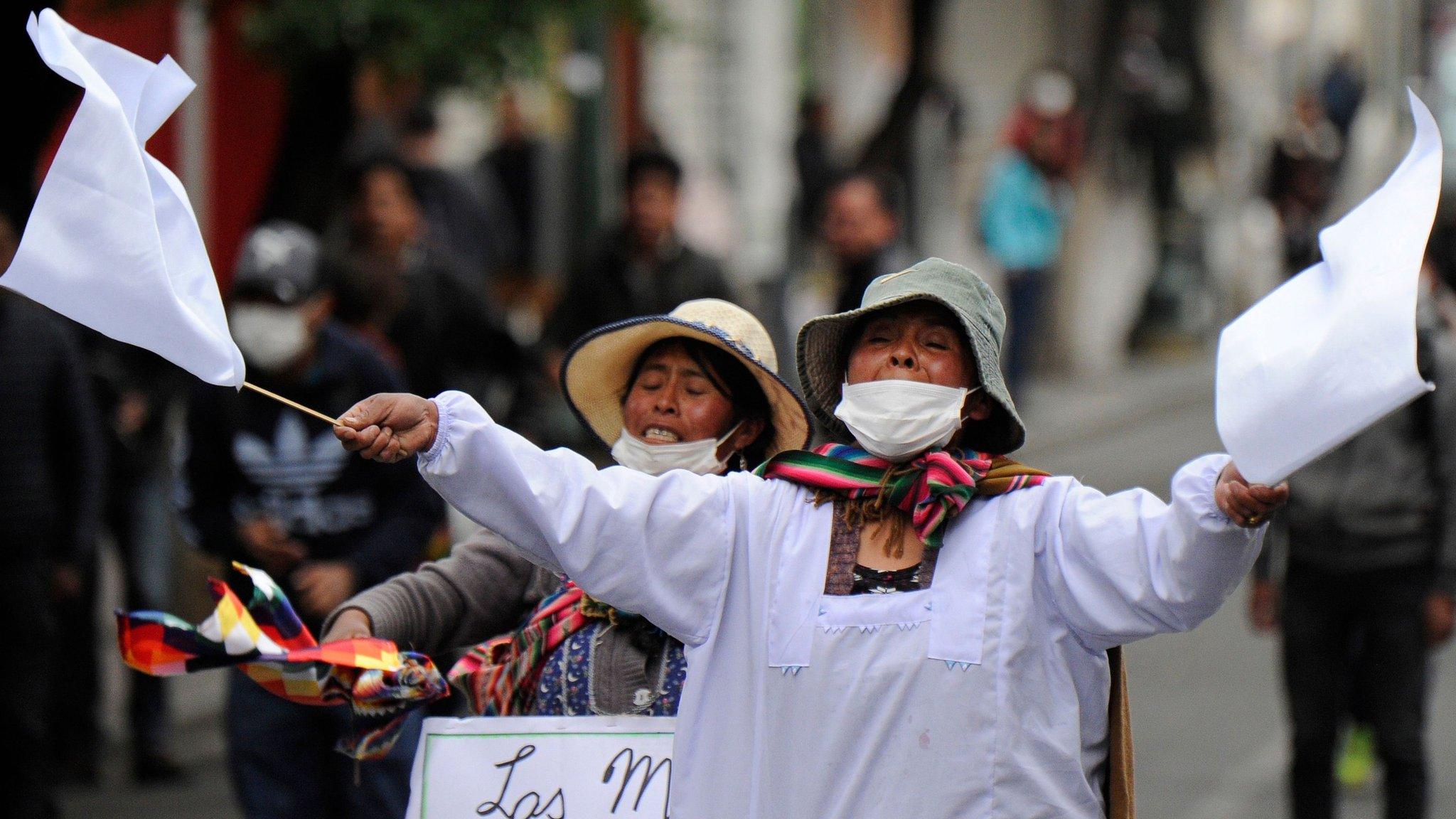 A supporter of Bolivian ex-President Evo Morales waves white flags during clashes with riot police following a protest in La Paz on 13 November, 2019.