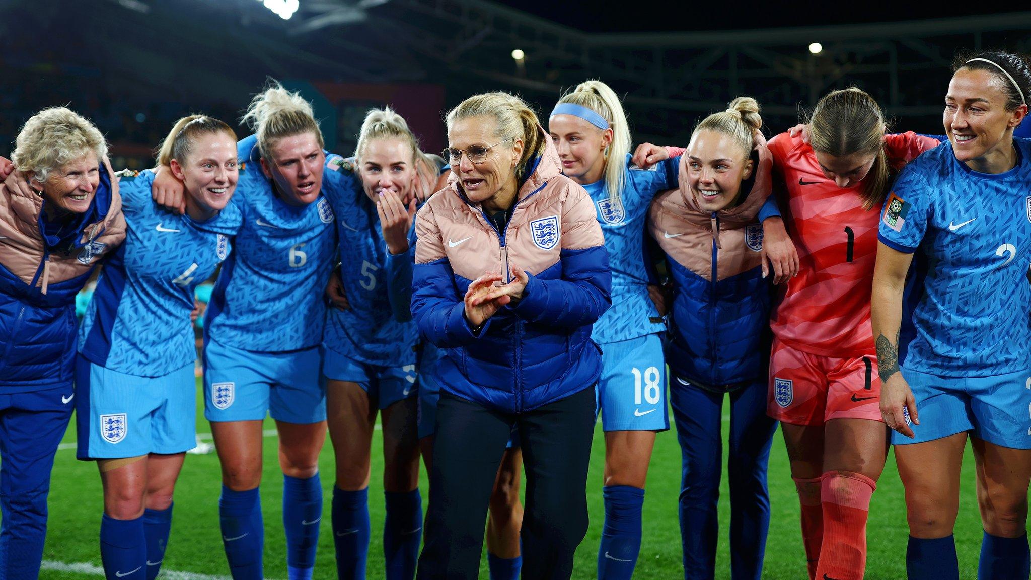 Sarina Wiegman stands in the middle of the post match huddle speaking to the players as they look on intently.