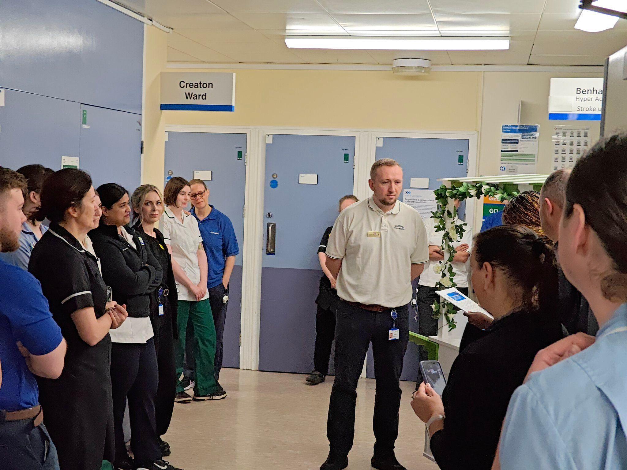 Richard Lee is presented with the award as colleagues look on 