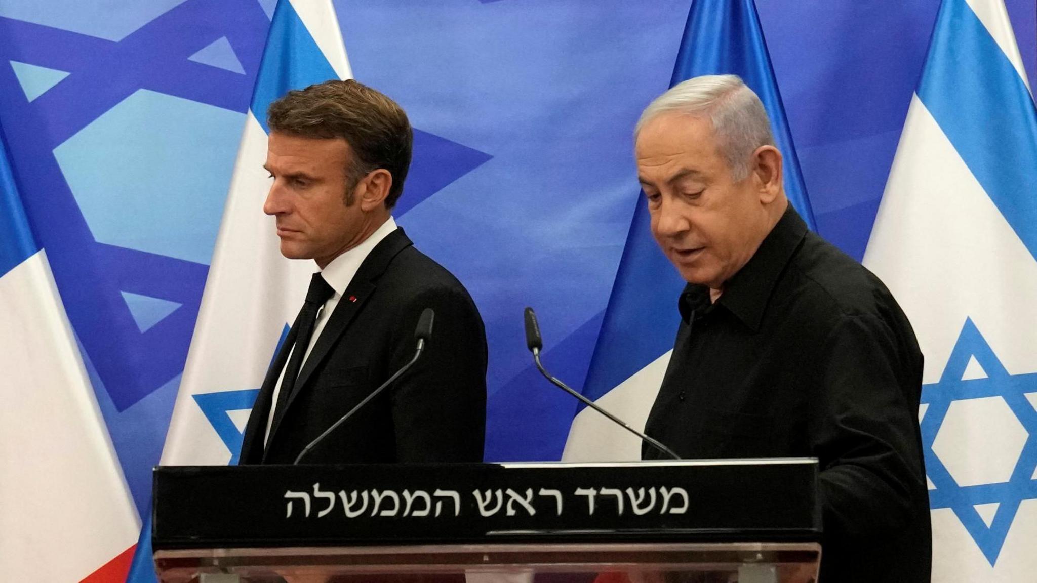 President Emmanuel Macron of France enters a press conference next to Israeli Prime Minister Benjamin Netanyahu.