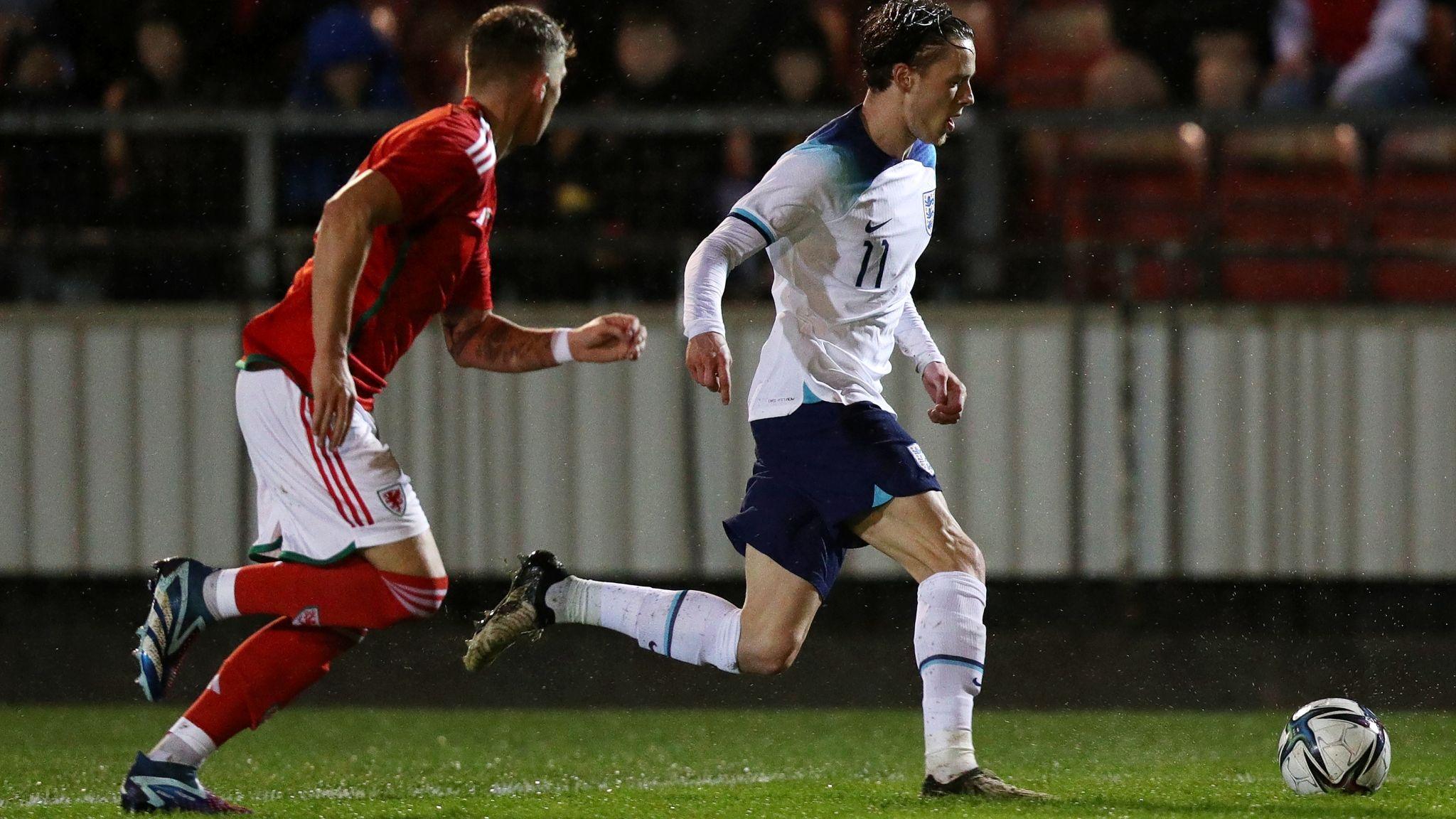 Reece Smith of England C runs with the ball whilst under pressure from Danny Gosset of Wales C 