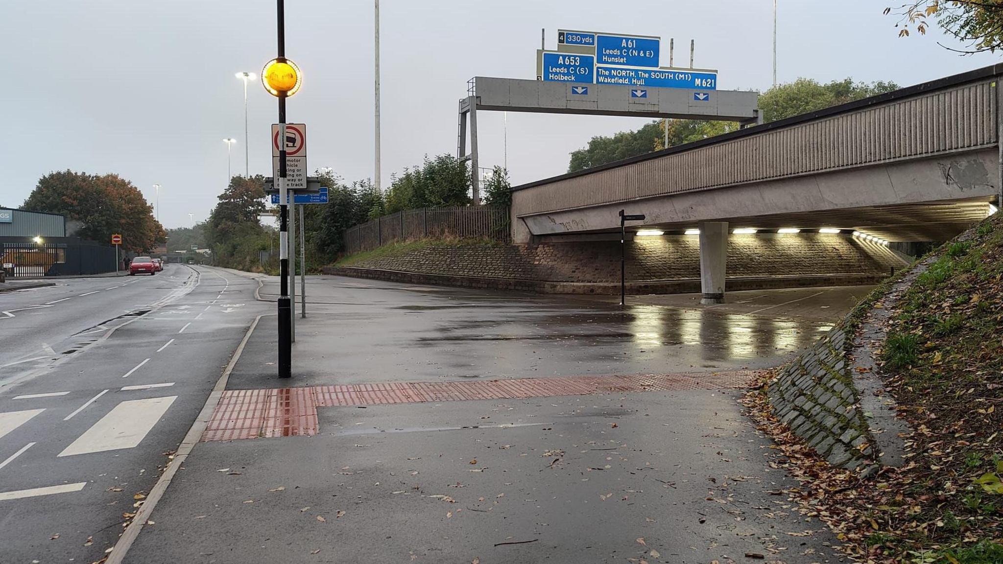 A street next to a zebra crossing, near an underpass