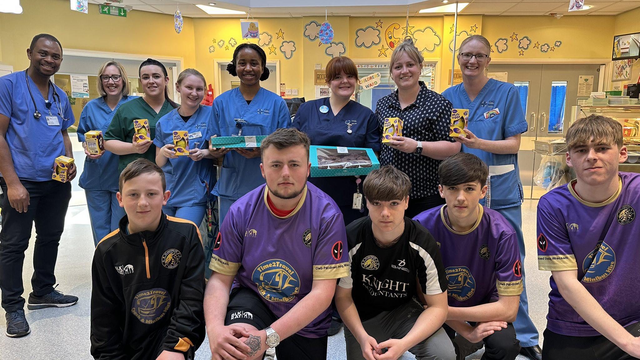 Football players and hospital staff holding Easter eggs