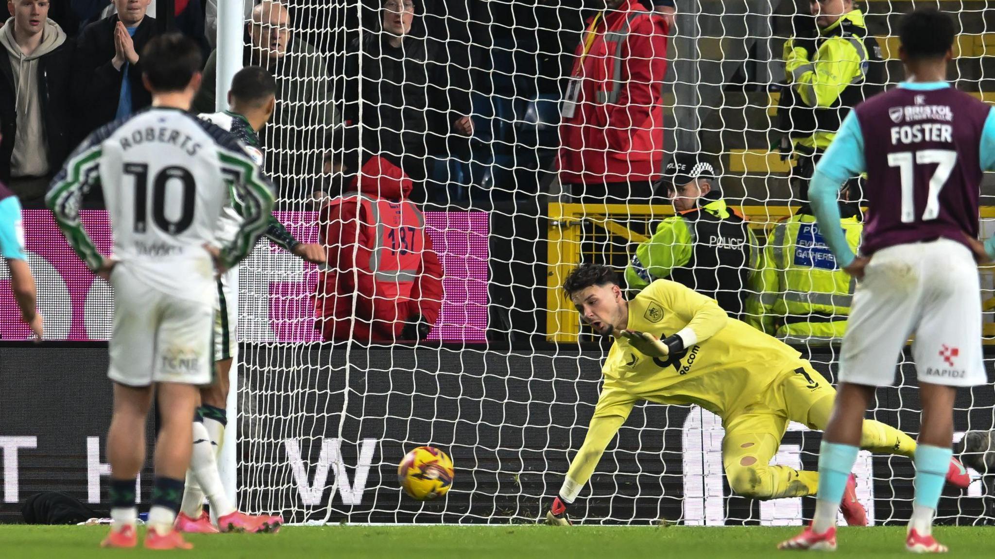 James Trafford dives low to save Wilson Isidor's penalty 