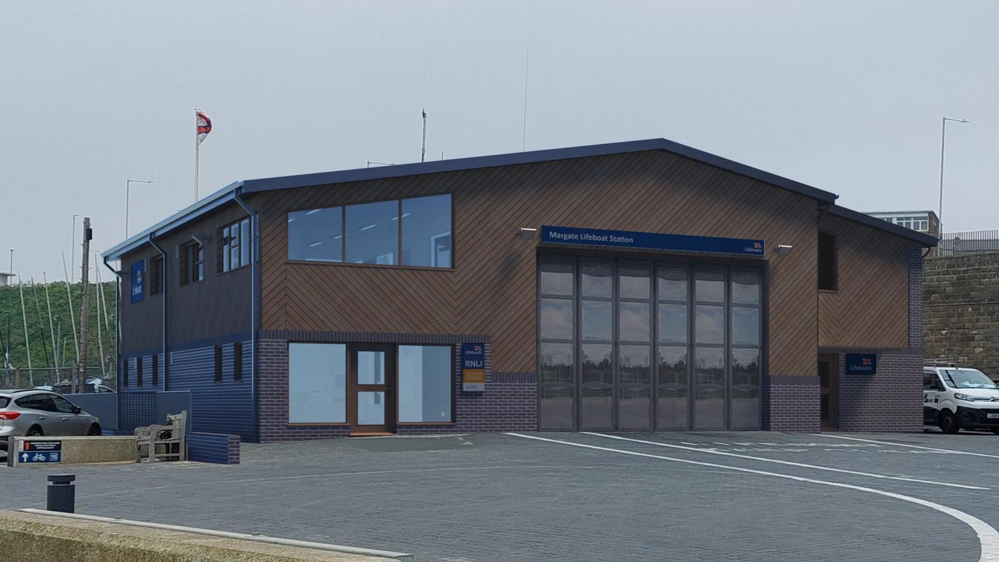 A generated image of what the new site is expected to look like. It is a two-storey building with dark wooden cladding on the outside and large glass windows at the front.