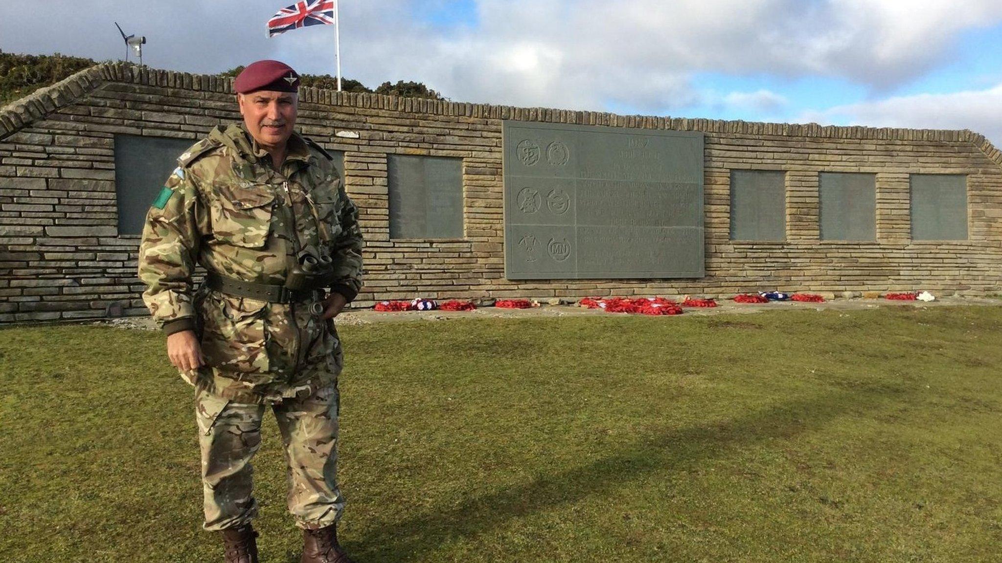 Thomas Noble stands beside a Falklands war memorial