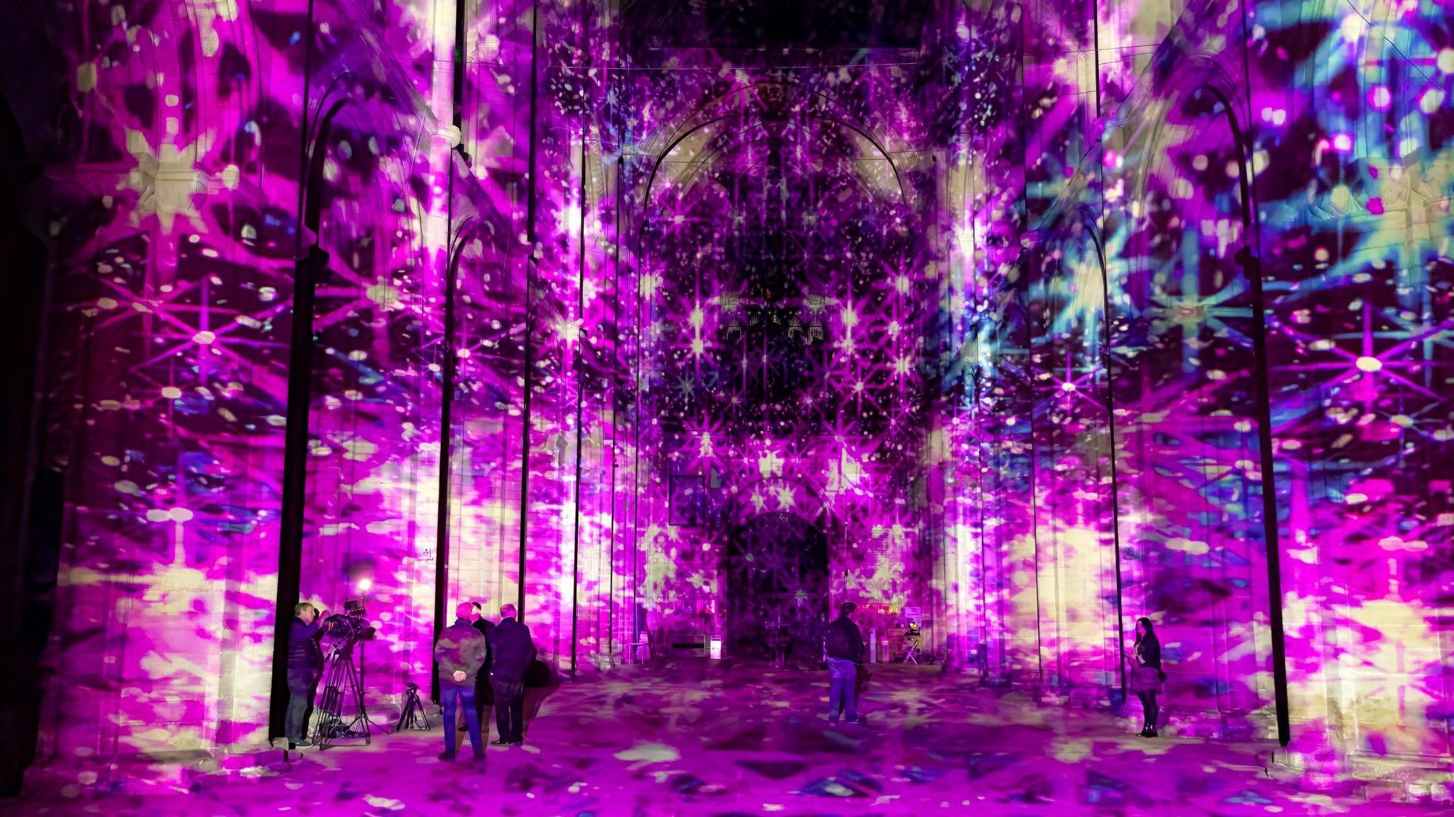 Inside the cathedral, with pink and purple lights projected on to the walls.