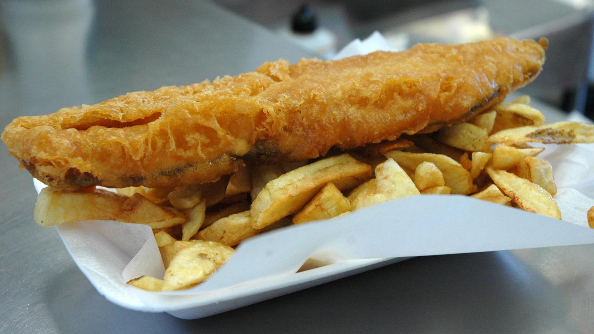 A portion of fish and chips on a counter. 