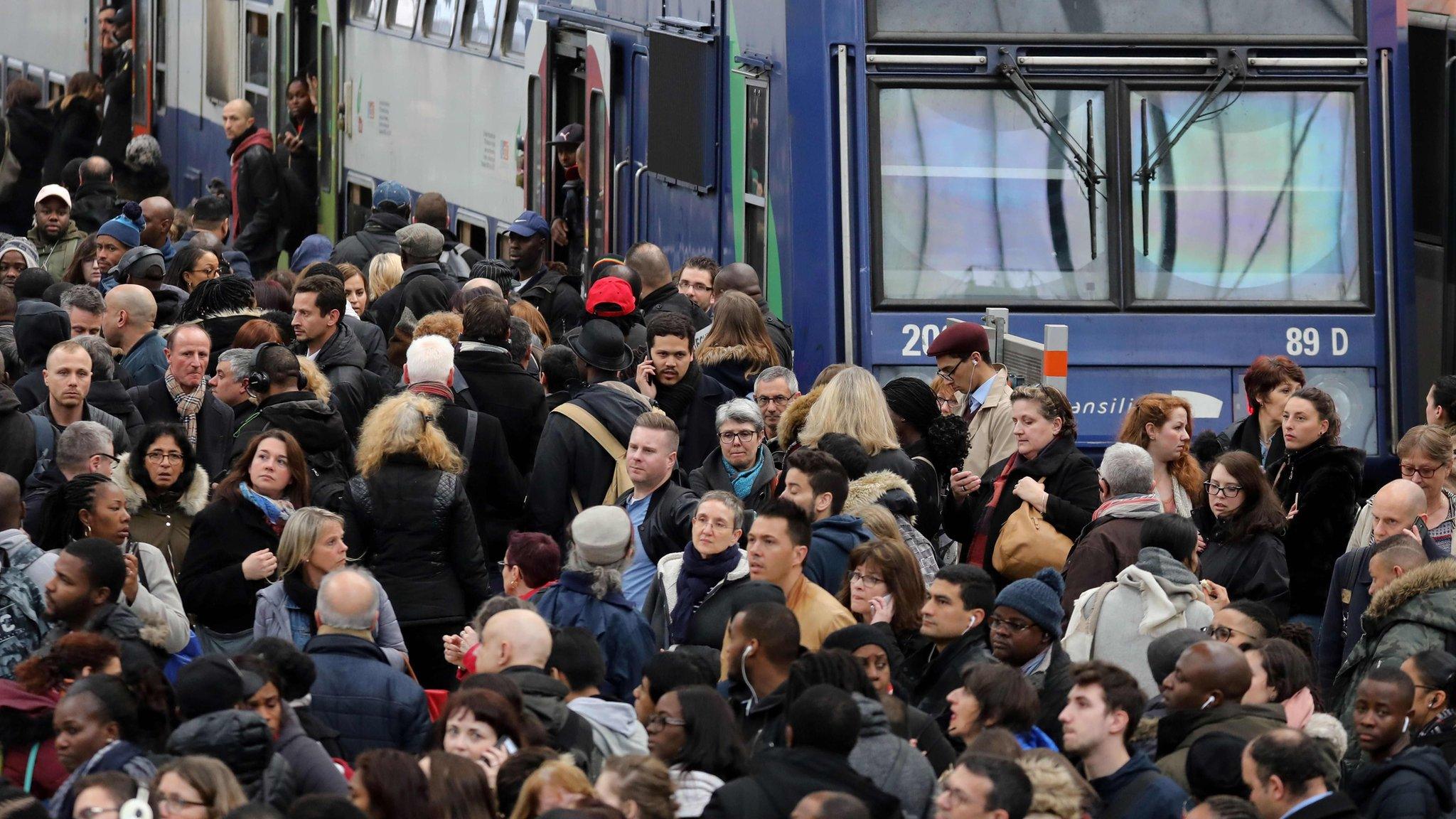 Commuters gather near a suburban train on a platform of the Gare de Lyon railway station