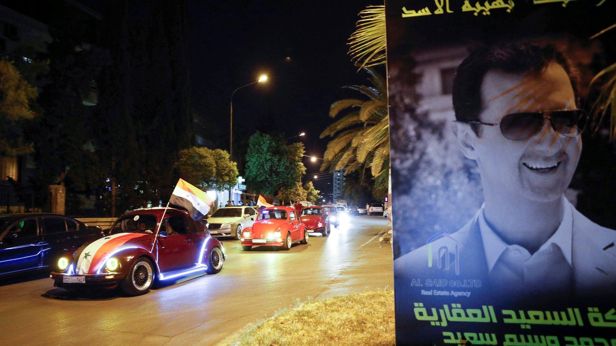 Assad supporters celebrate him winning the election