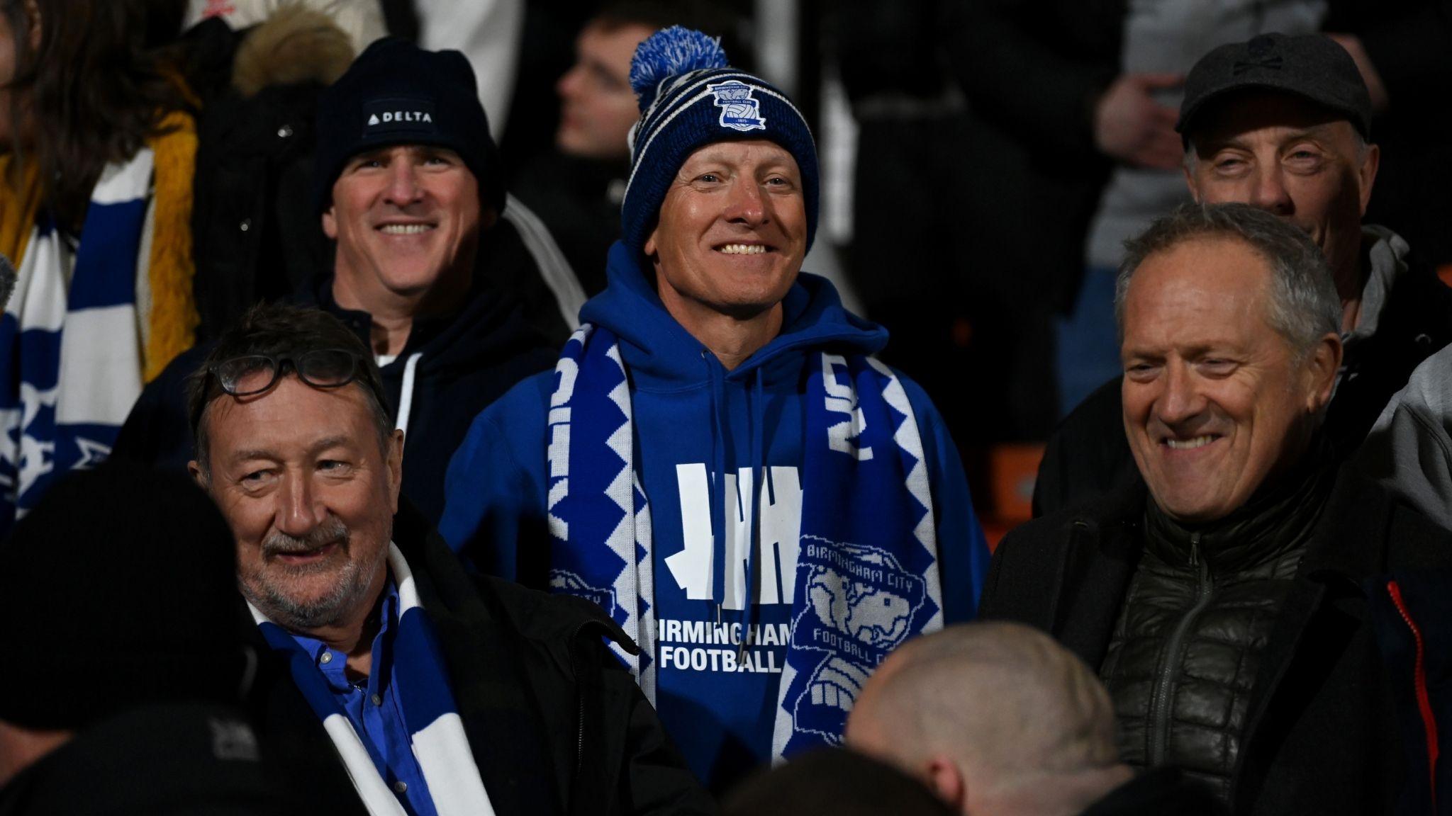 Birmingham City chairman Tom Wagner (centre) sat among the Birmingham fans at the Racecourse along with Peaky Blinders writer Steven Knight (left)