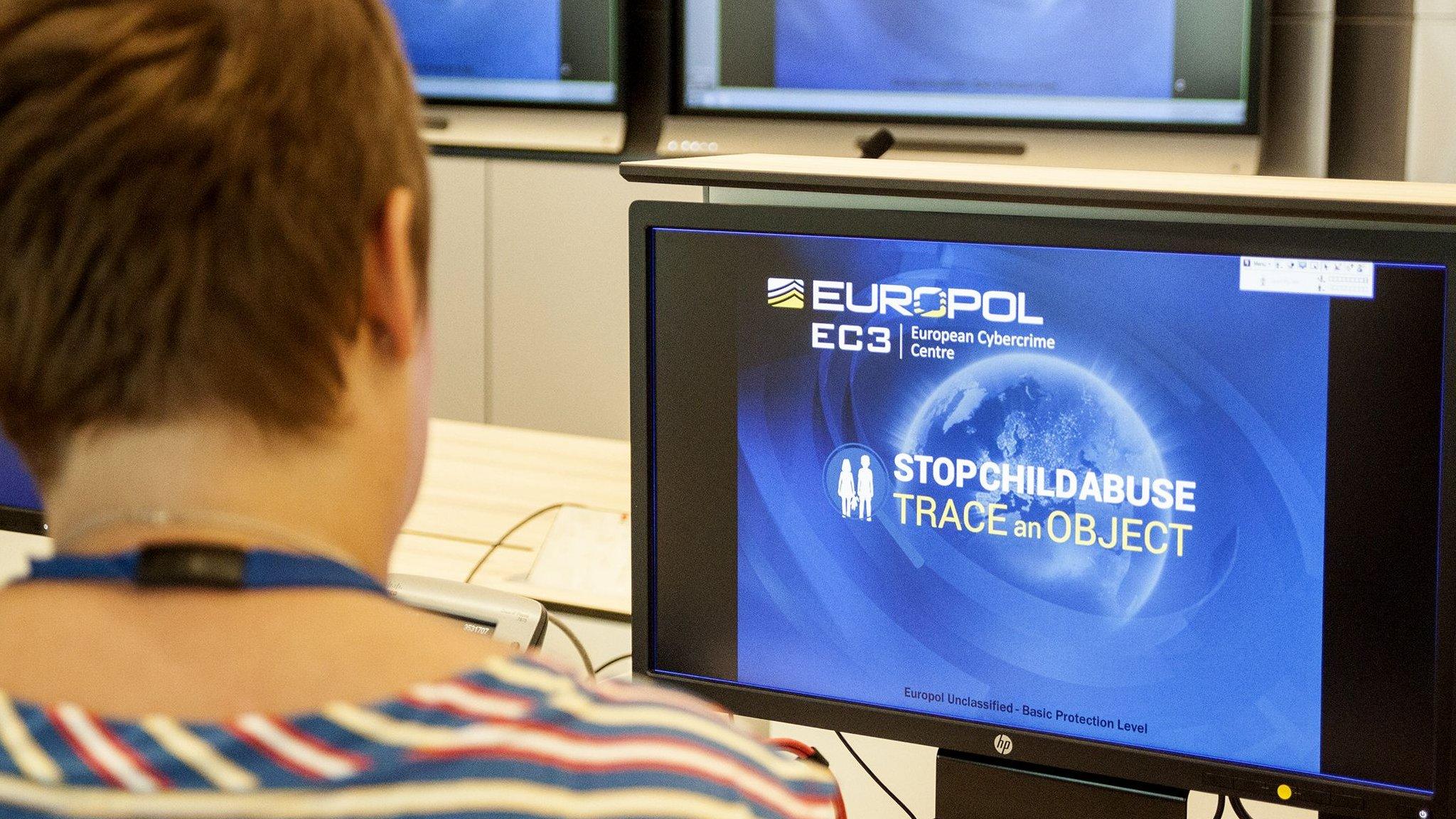 A Europol police agent looks at the onscreen logo of a new website launched by Europol at the Europol headquarters in The Hague on May 31, 2017