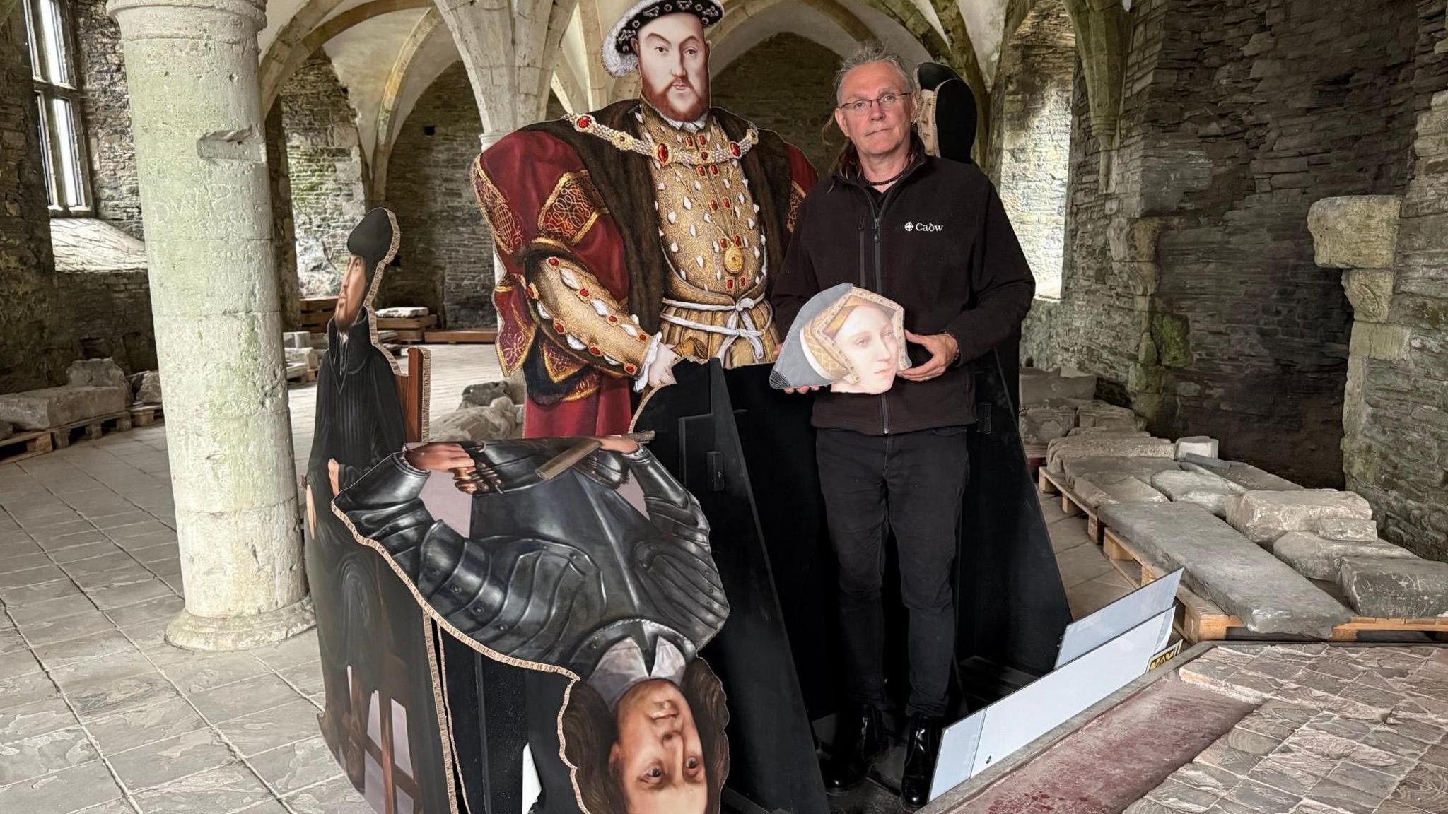 Jon Berry from Cadw stands next to a Tudor exhibition, including a cut out of King Henry VIII which was vandalised at Neath Abbey. Jon is holding the head of Jane Seymour from the exhibition which was torn off by vandals.