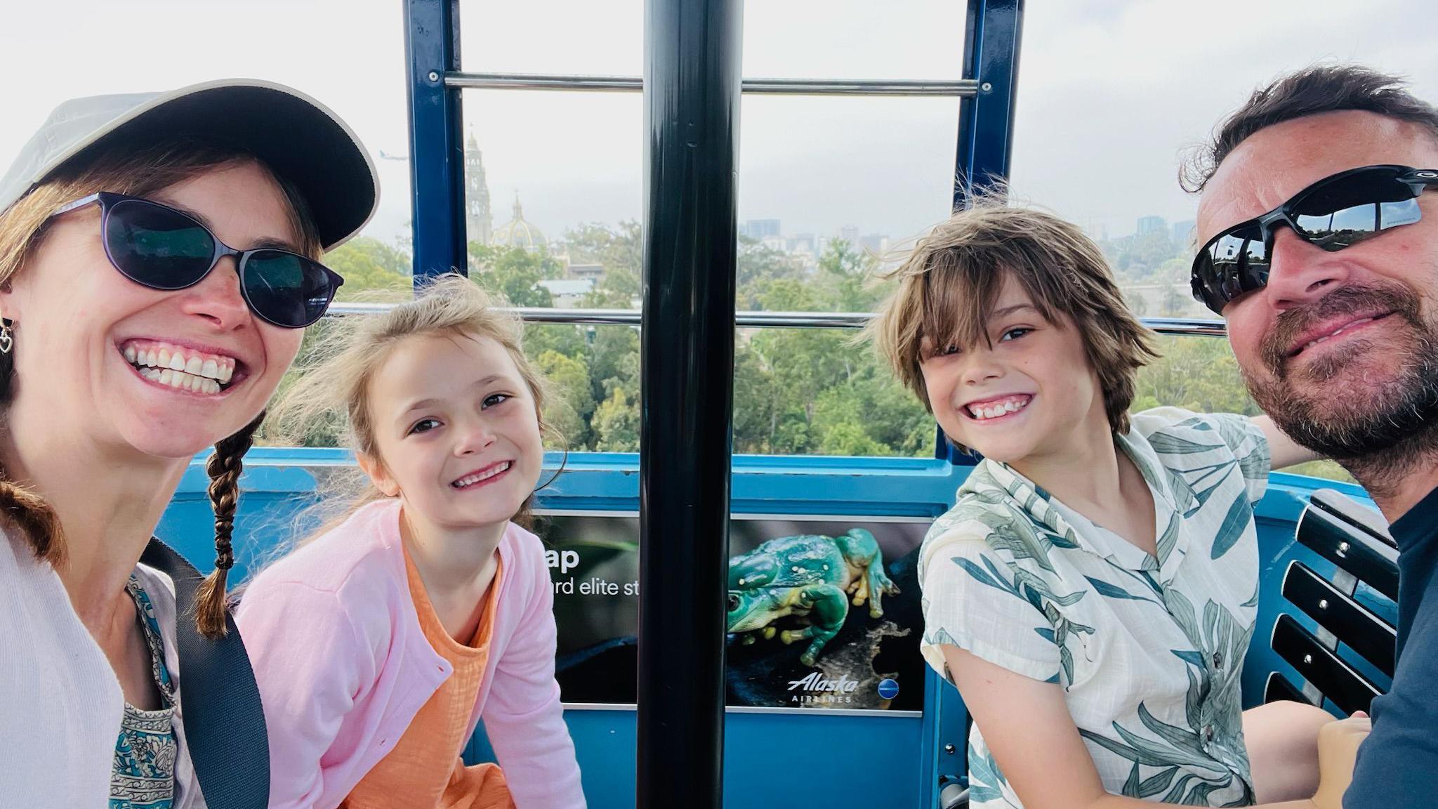 A family photo of a mum, a young daughter and son, and father enjoying a sunny day out. 