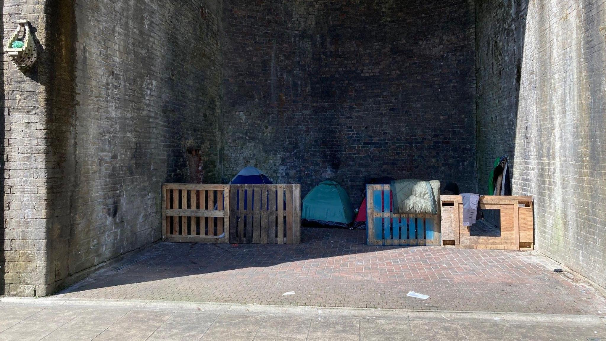 Wooden pallets are used to create makeshift camps an archway