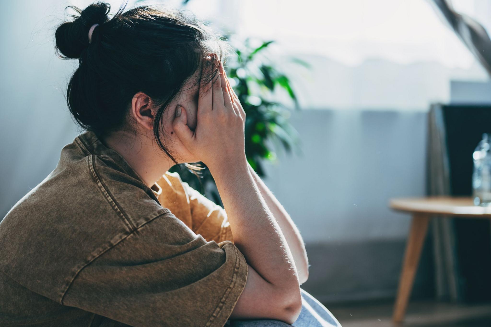 Stock image of woman with her head in her hands