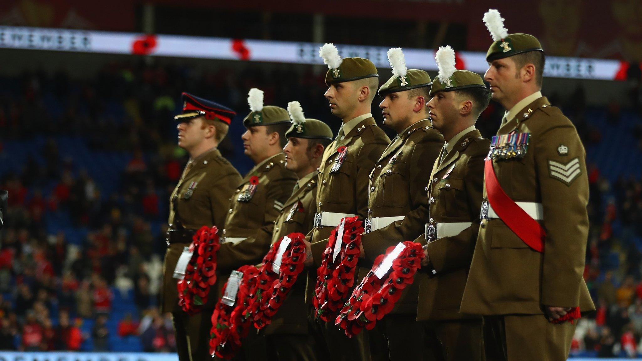 Soldiers hold poppy wreaths ahead of Wales and Serbia's 2018 World Cup Qualifier