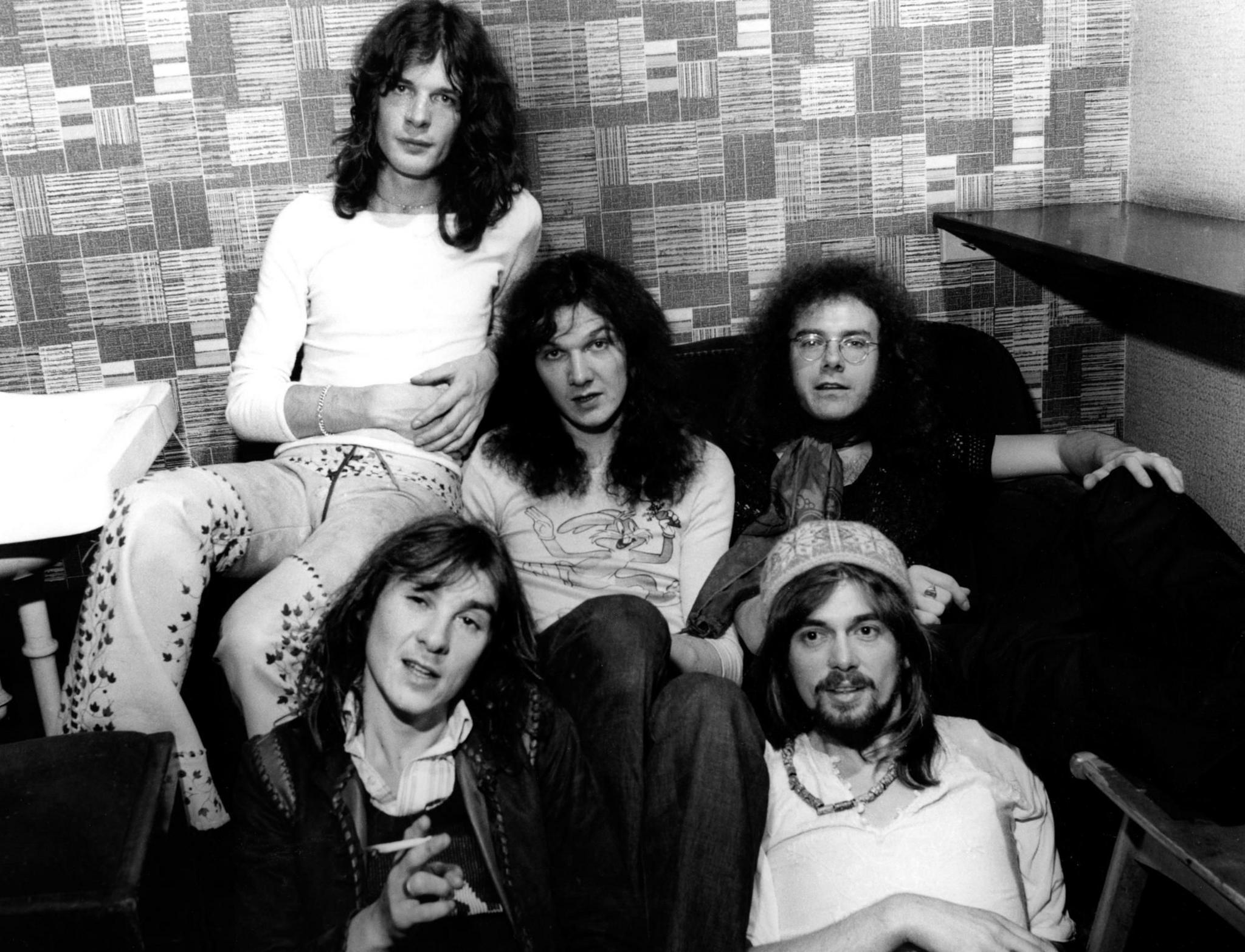 A black and white photo of King Crimson sitting in a dressing room. The five members include Pete Sinfield and Robert Fripp.