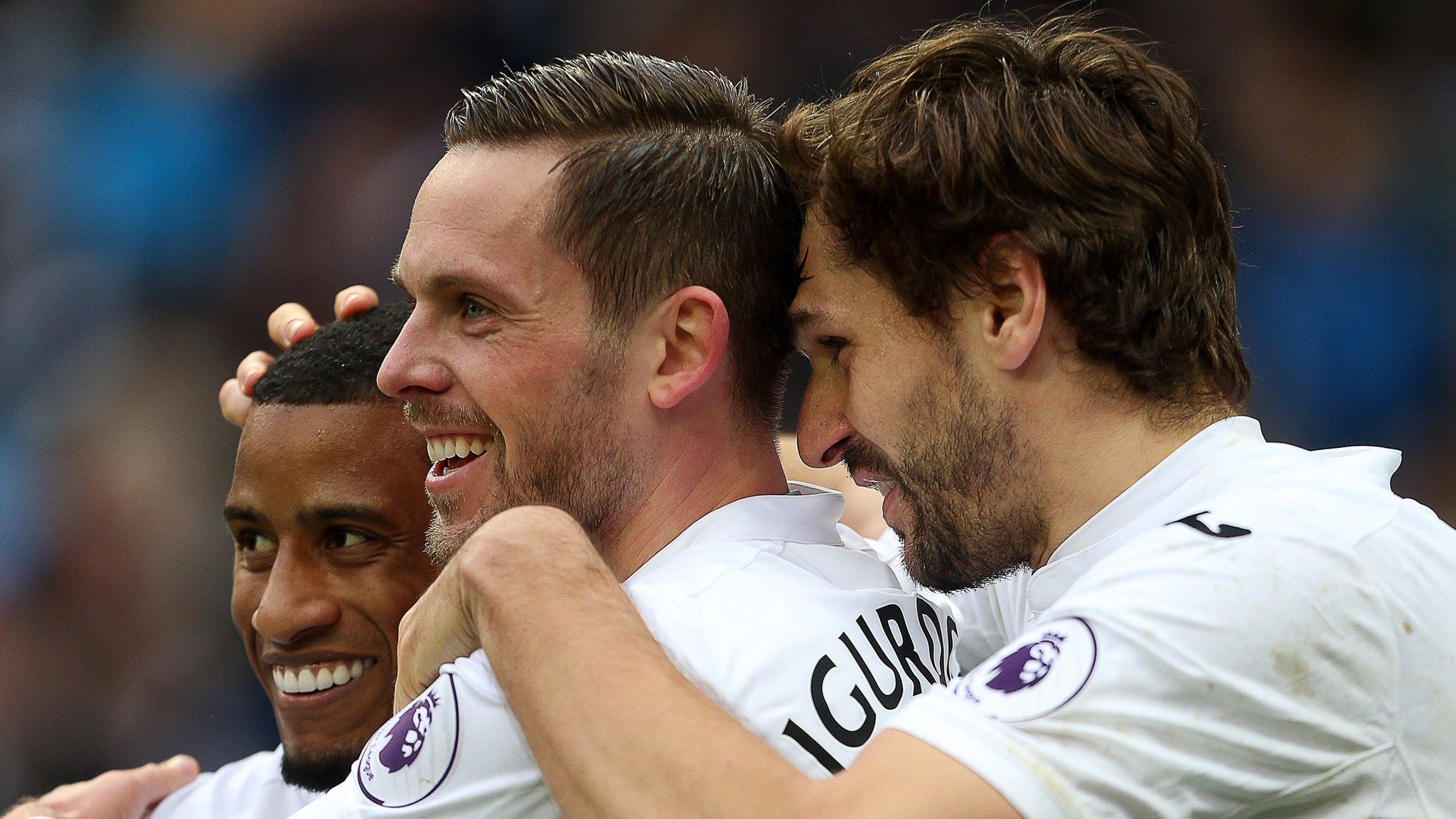 Gylfi Sigurdsson celebrates scoring a goal at Manchester City with Luciano Narsingh (L) and Fernando Llorente