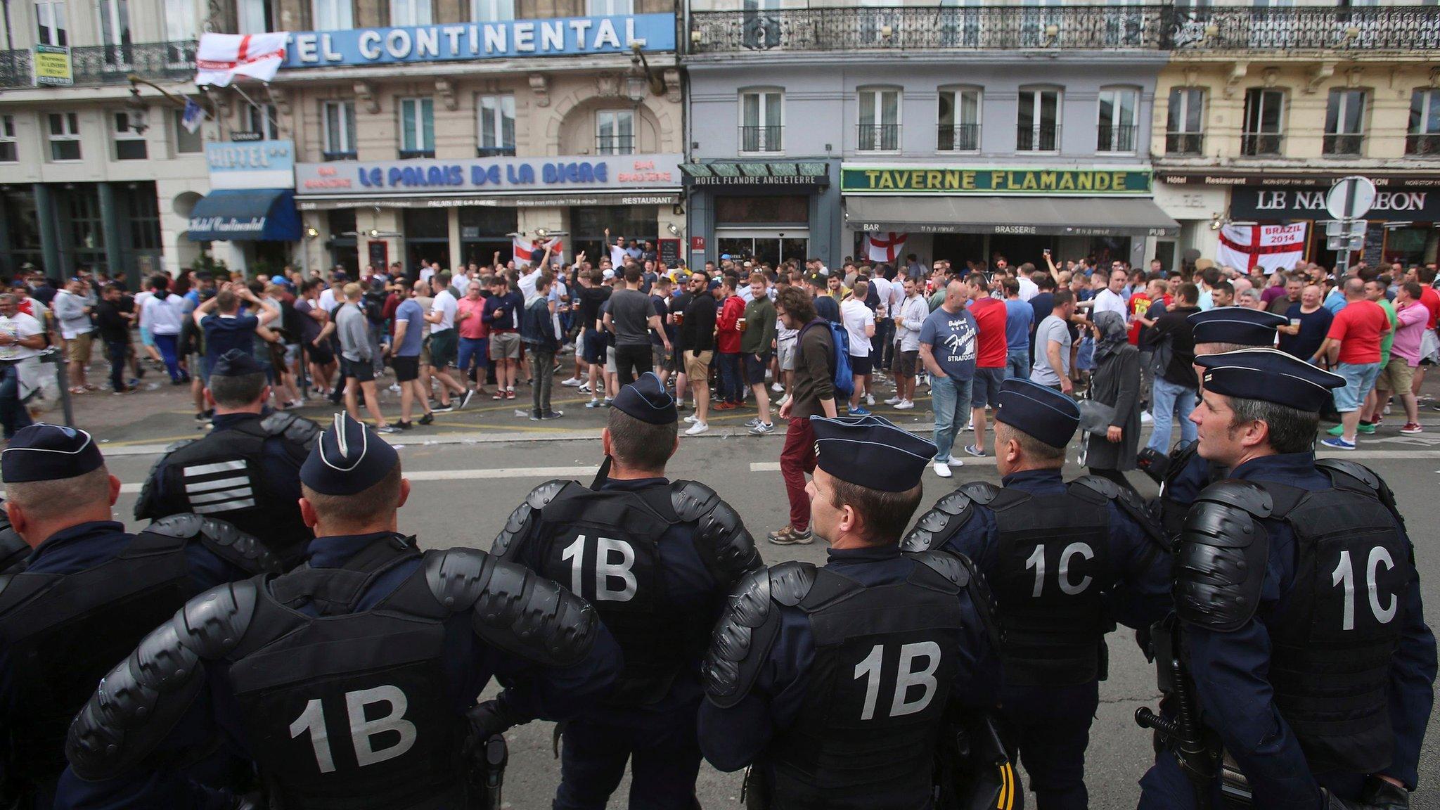 French police watch England fans outside a bar in Lille, on Wednesday 15 June during Euro 2016
