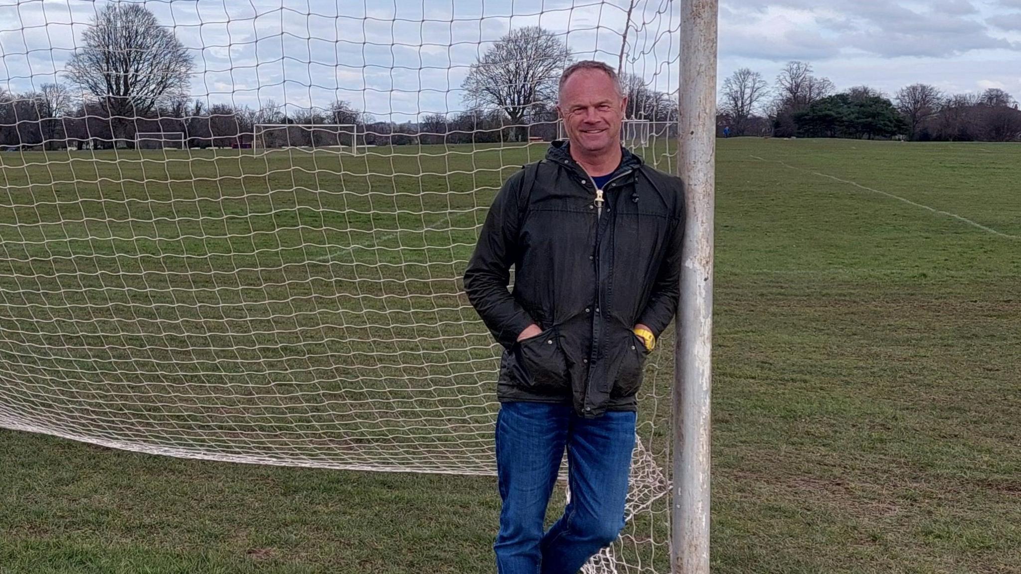 Jonathan Gould leaning against football goalpost on the Bristol Downs