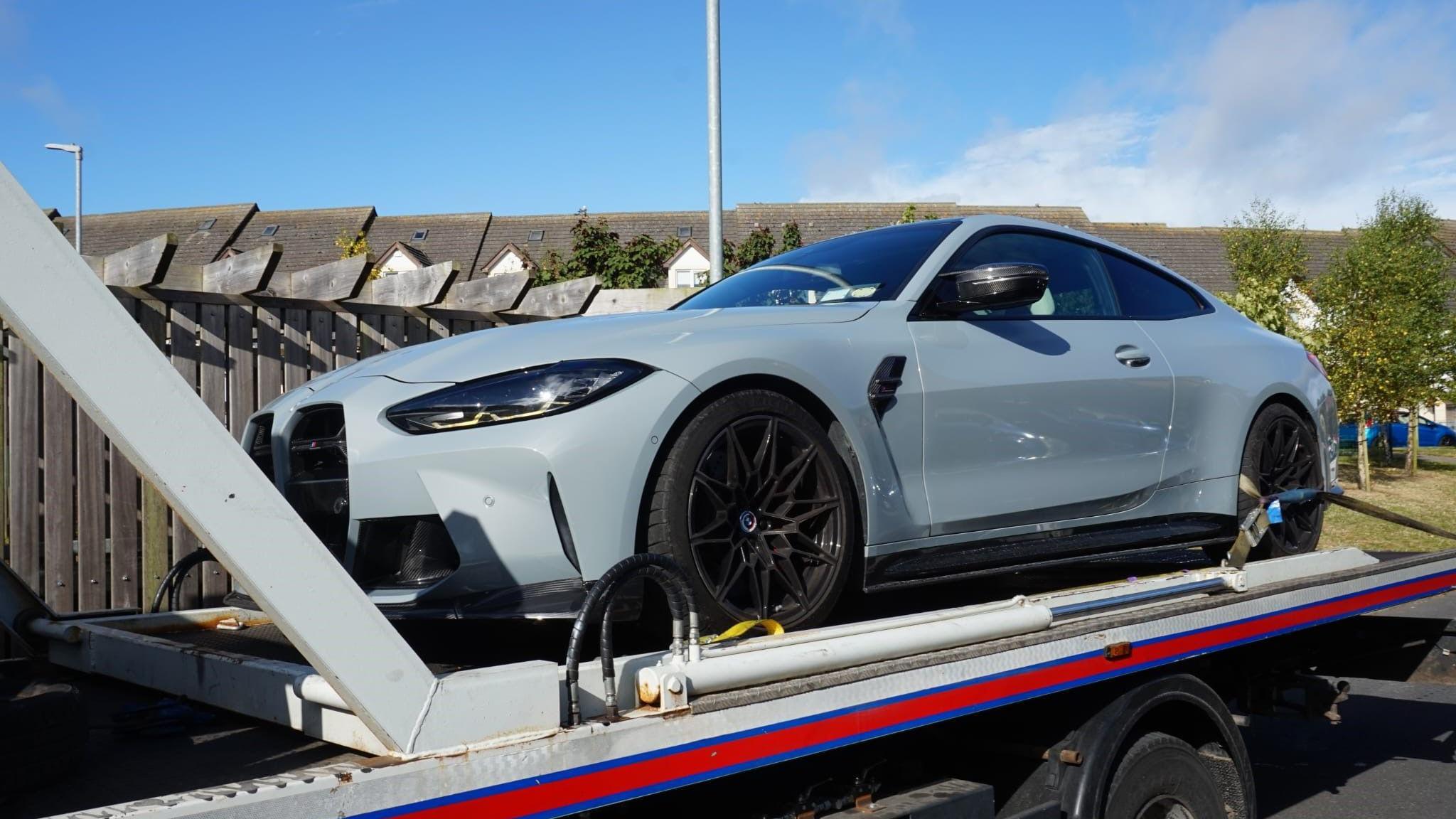 A grey car on the back of a truck