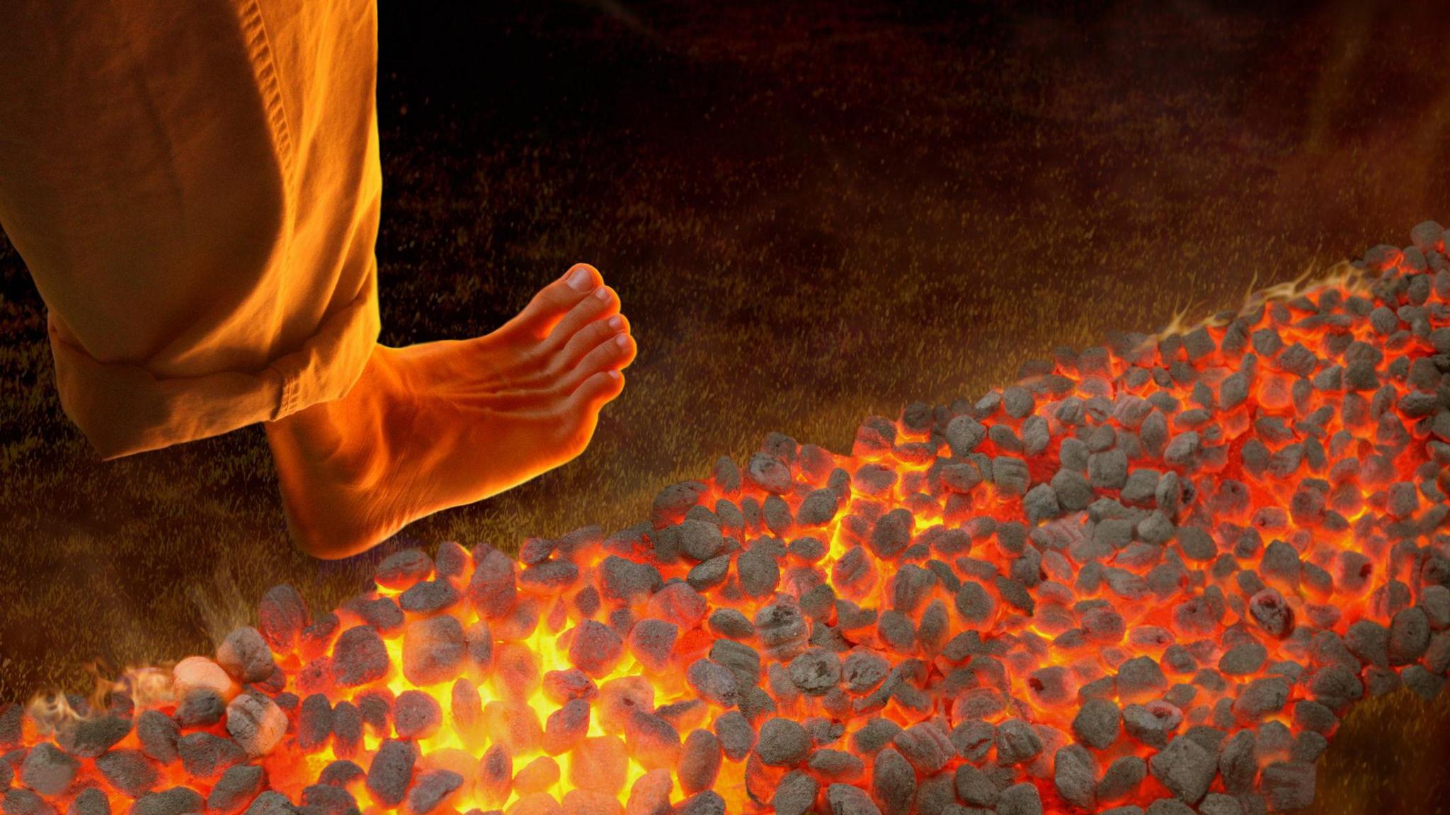 Man walking barefoot on hot coals, high angle view, close-up of foot - stock photo