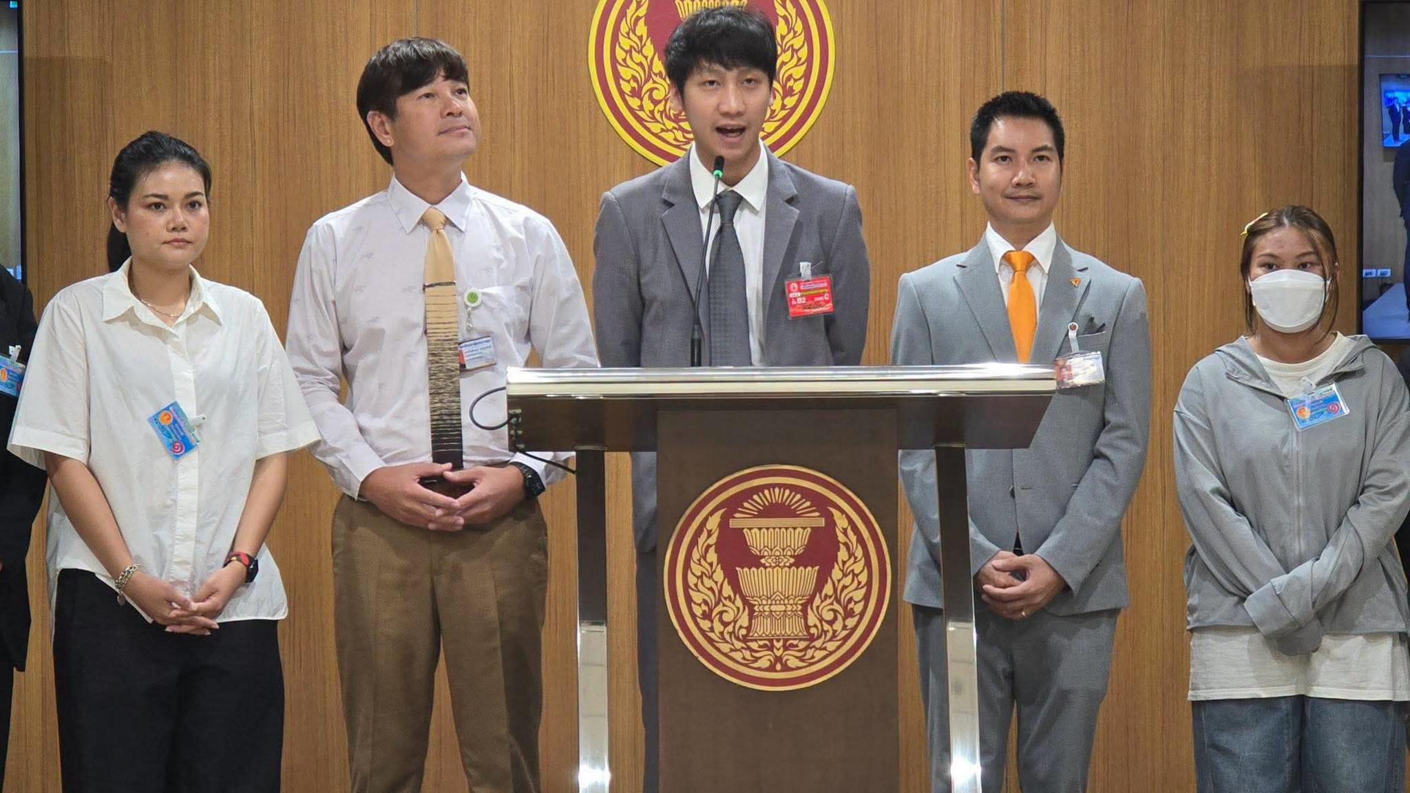 Juraluk Kunaruk (first from right), standing before the Thai parliament as MP Nitikorn Bunyakulcharoen (centre) addresses lawmakers on the spate of scams around BTS concert tickets