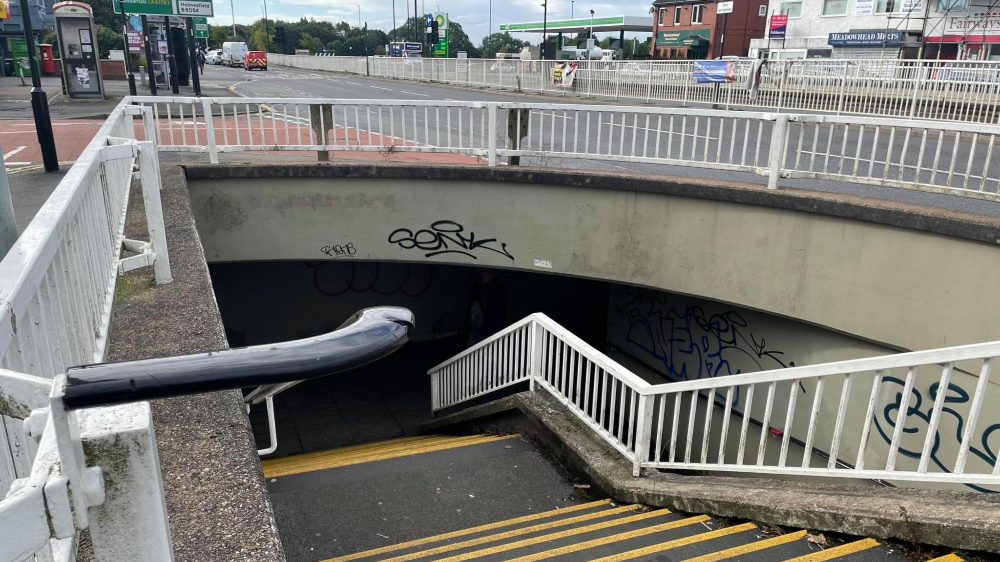 Steps leading down to a dark underpass