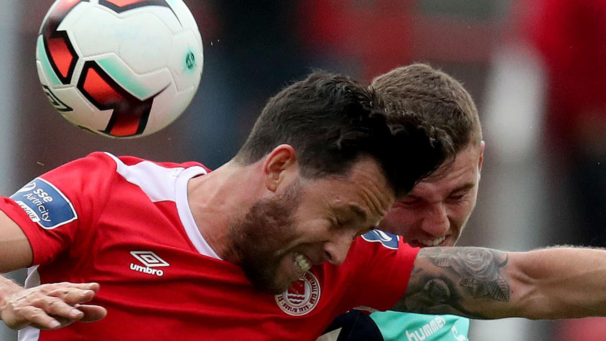 Billy Dennehy of St Pat's goes for a high ball with Derry defender Harry Monaghan