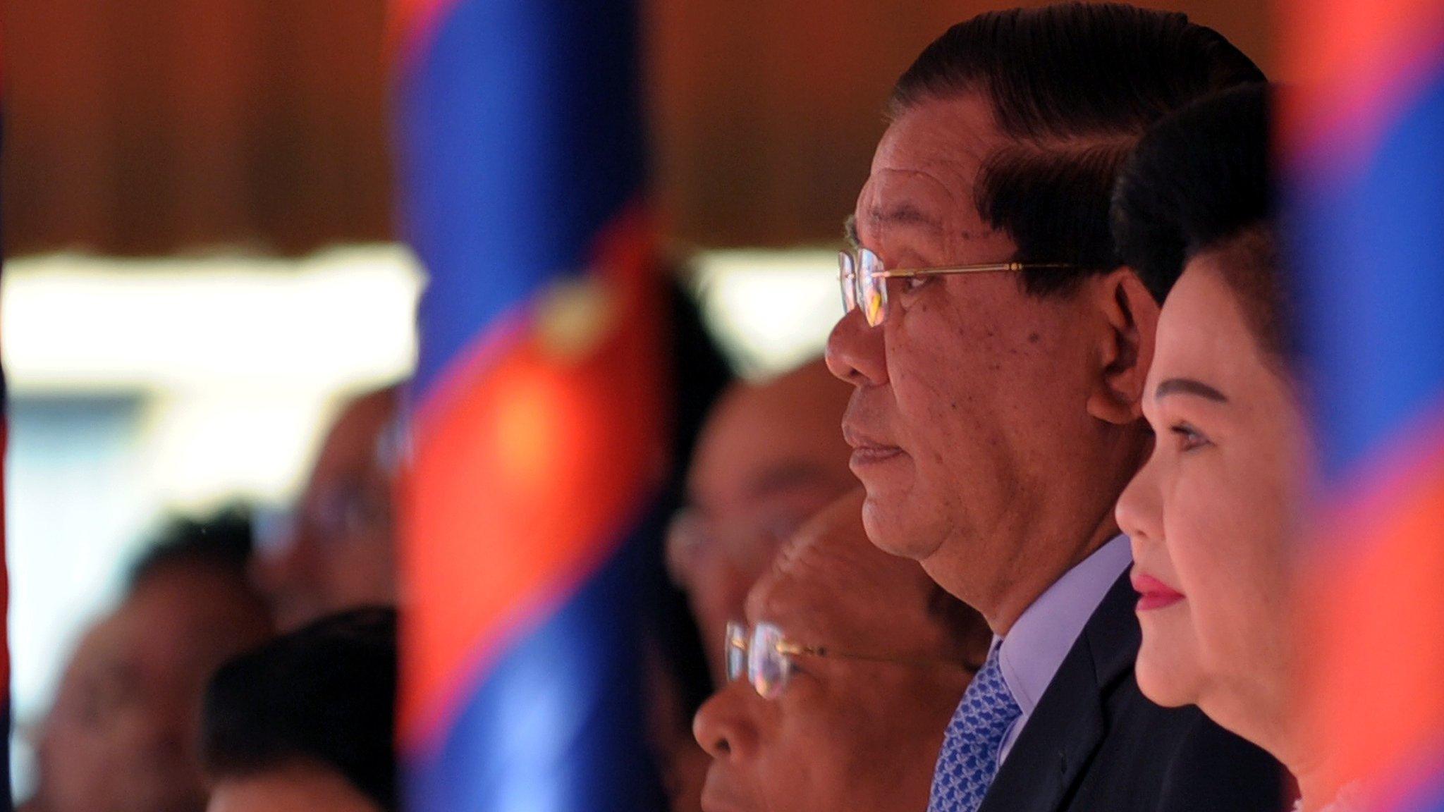 Cambodian Prime Minister Hun Sen (centre R) and his wife Bun Rany (R) listen to the national anthem during a Cambodian People's Party (CPP) ceremony marking the 36th anniversary of the fall of the Khmer Rouge regime in Phnom Penh on January 7, 2015