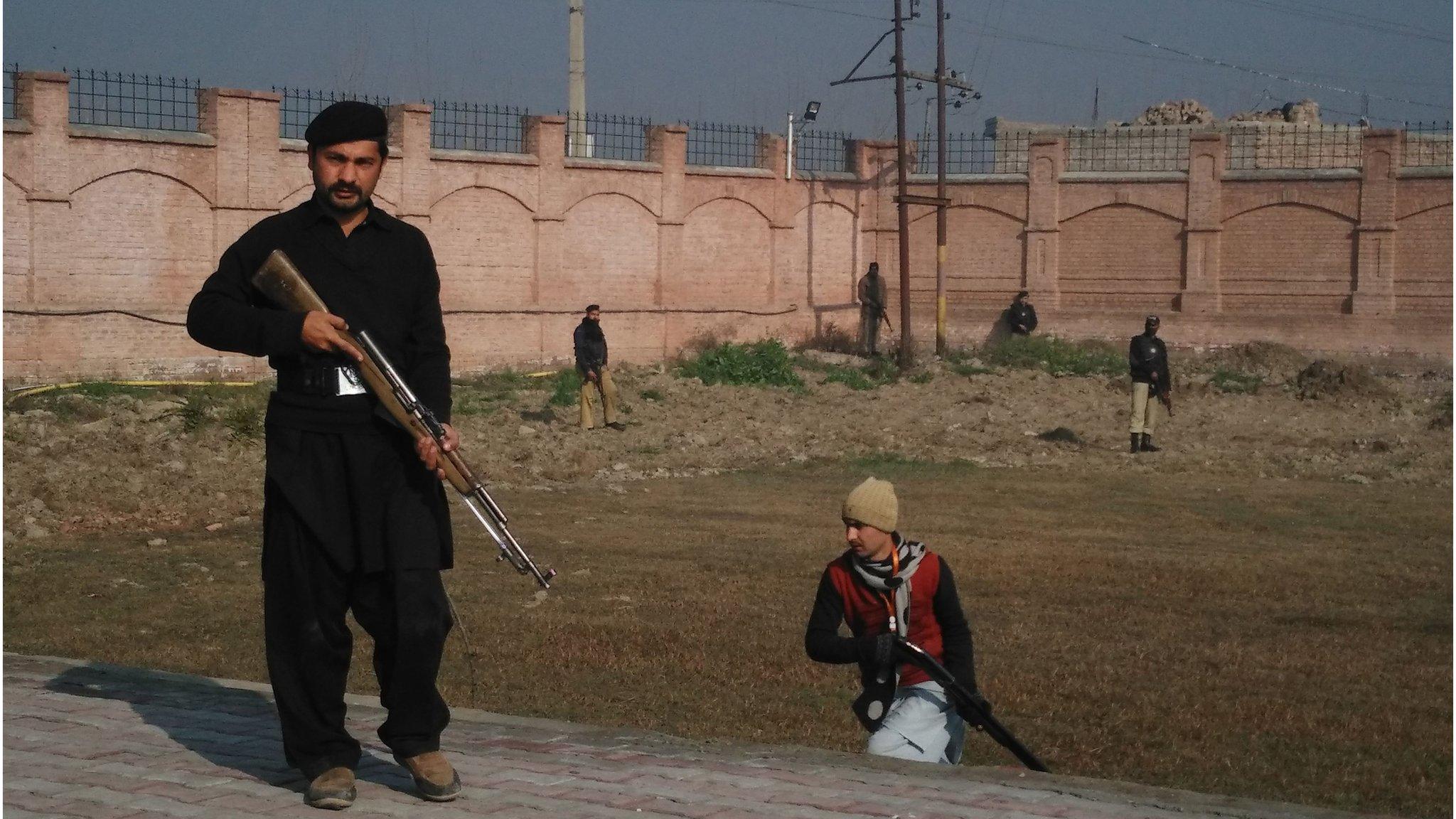 Pakistani security personnel taking position outside the Bacha Khan university following an attack by gunmen in Charsadda.