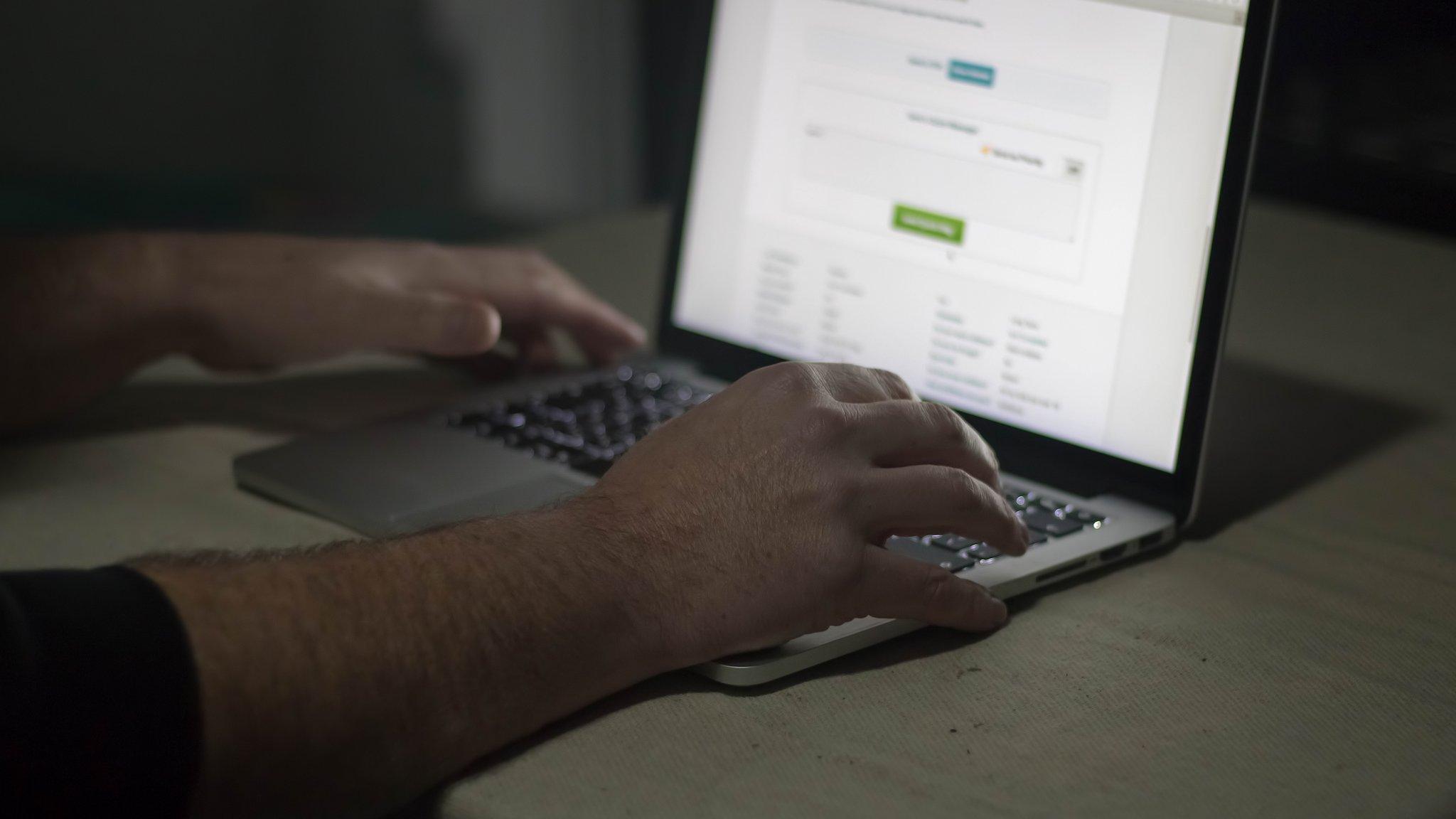 A man's hands at a lap top