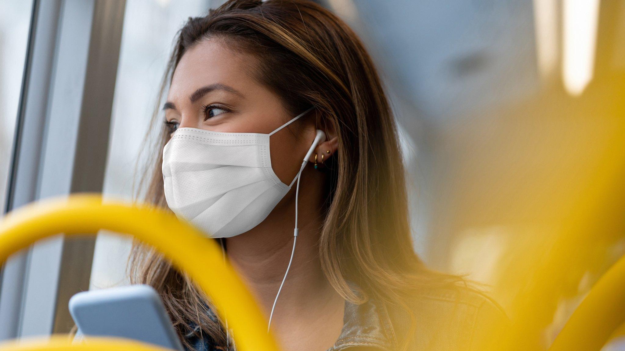 A woman in a face mask on a bus