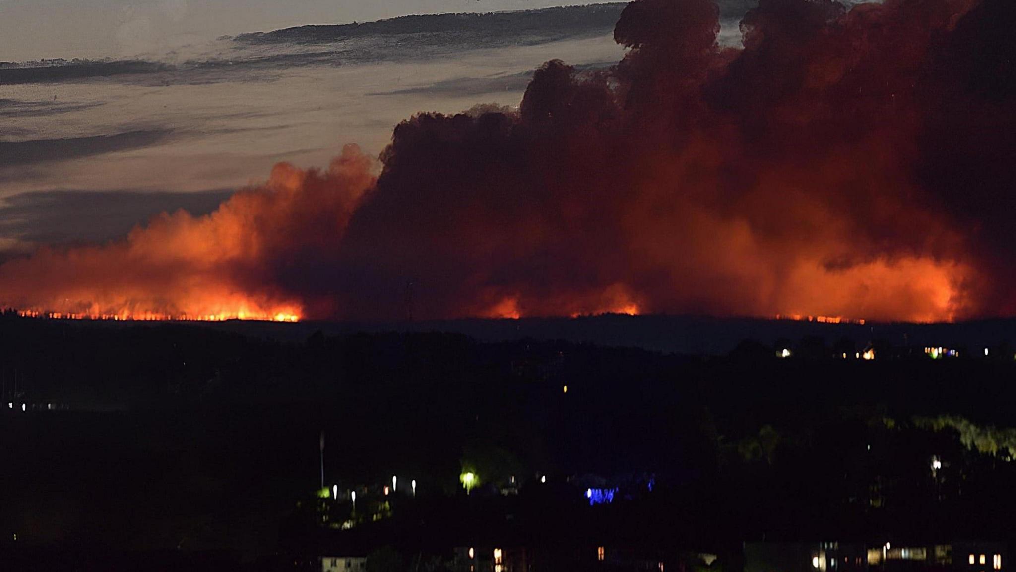 A large blaze on moorland seen from a distance at night