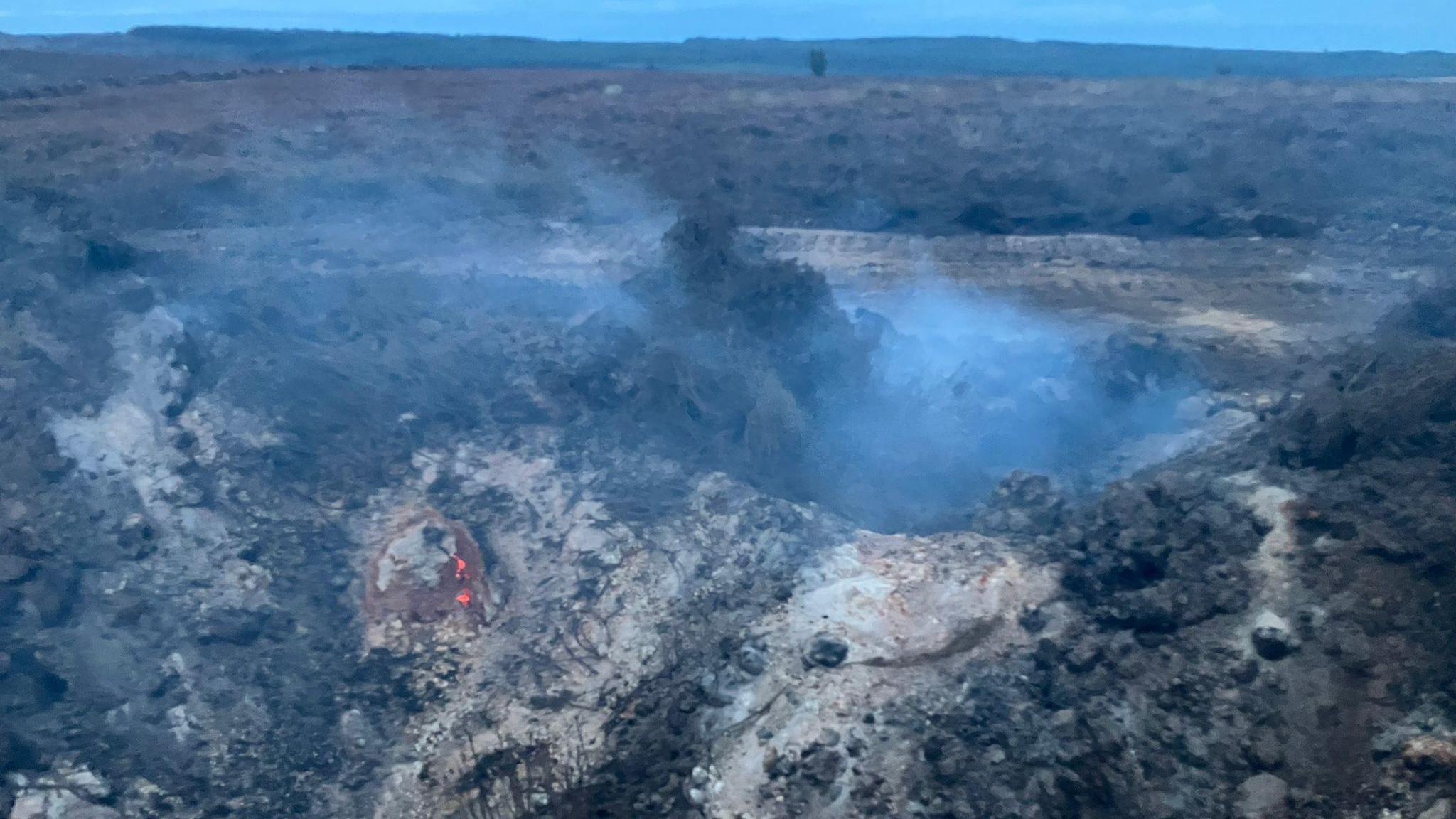 This is a picture of the aftermath of the Langdale Moor fire: grey, dusty and cratered, with smoke still rising.