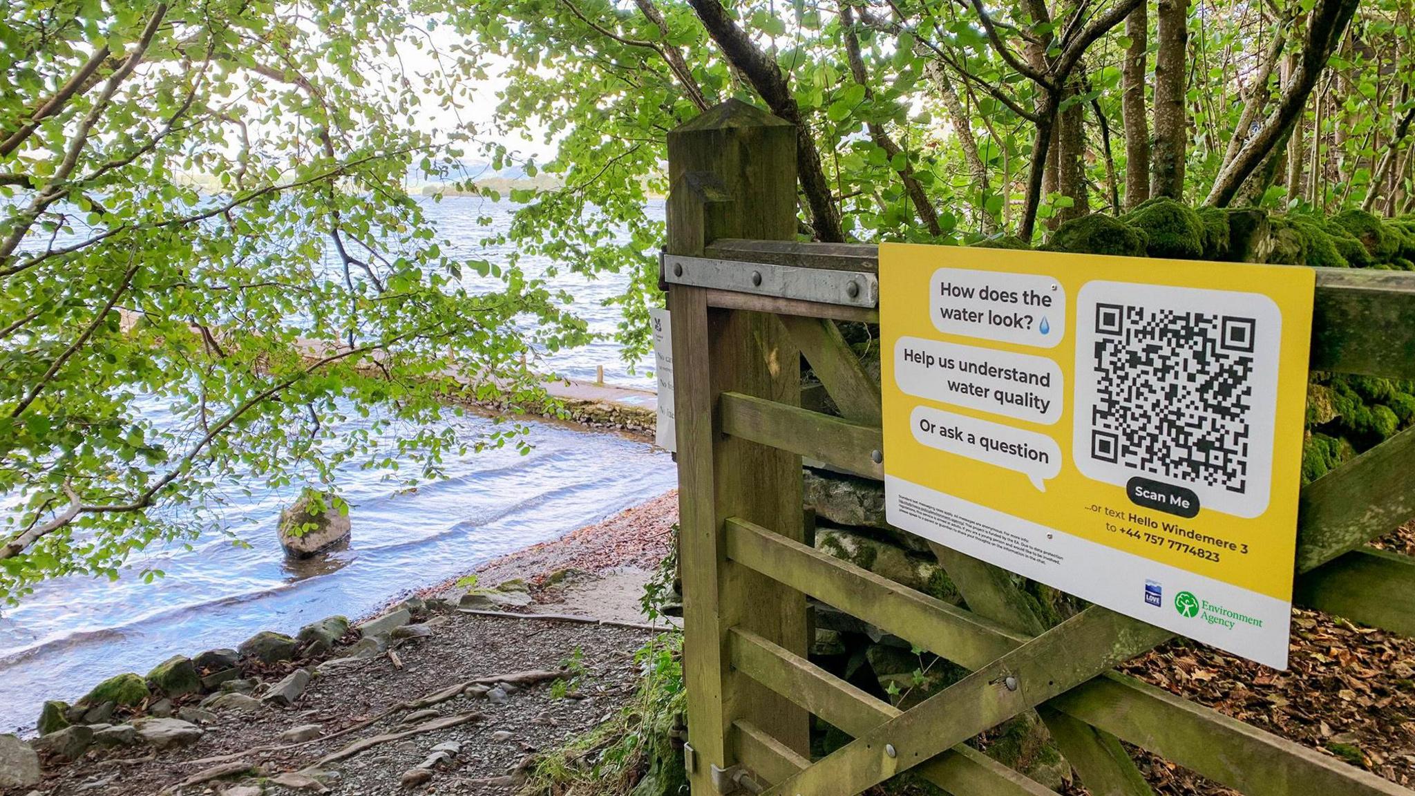 A Hello Lamp Post QR code on a gate by Windermere's shoreline. 