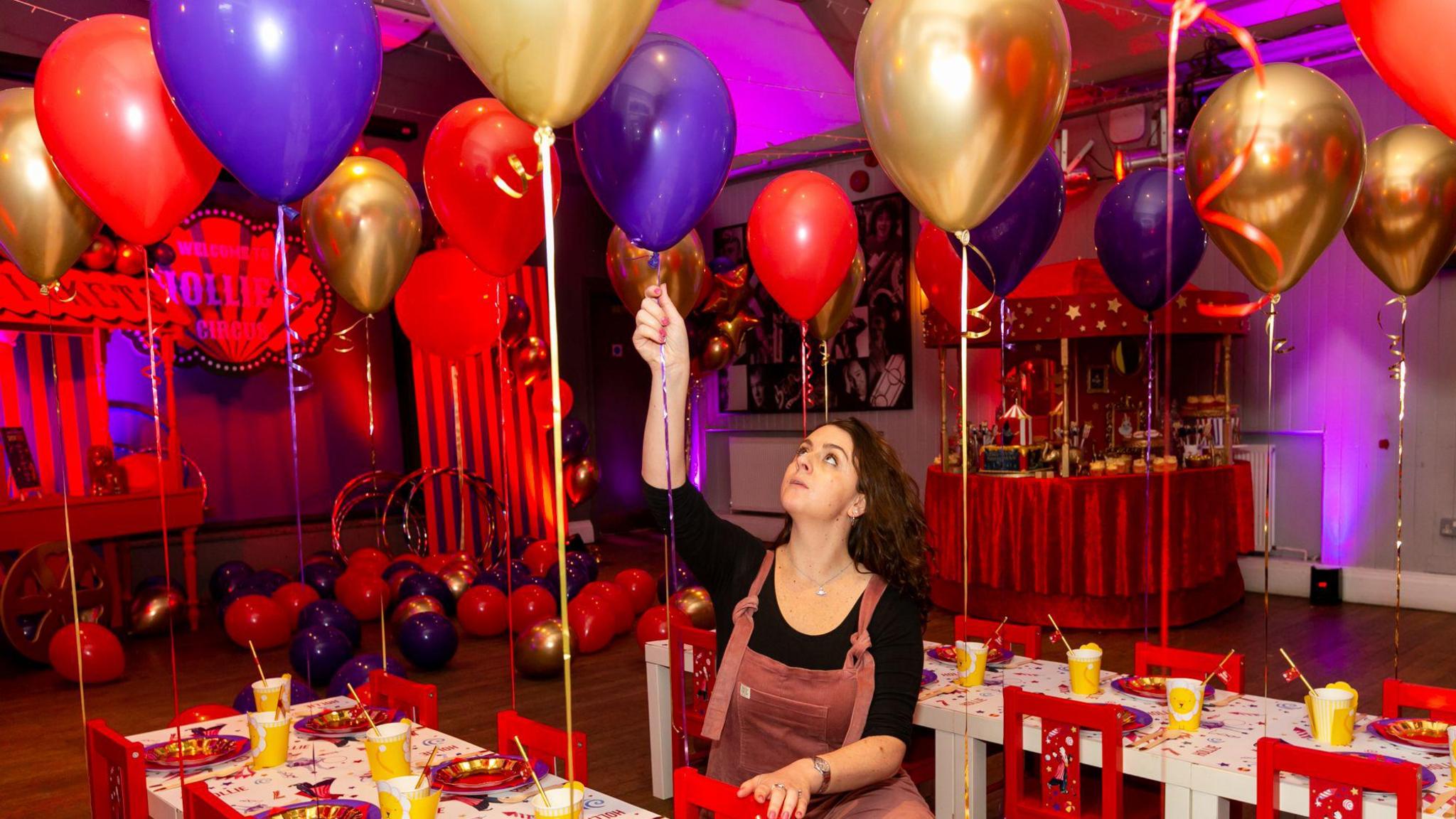 A woman looks up at a balloon