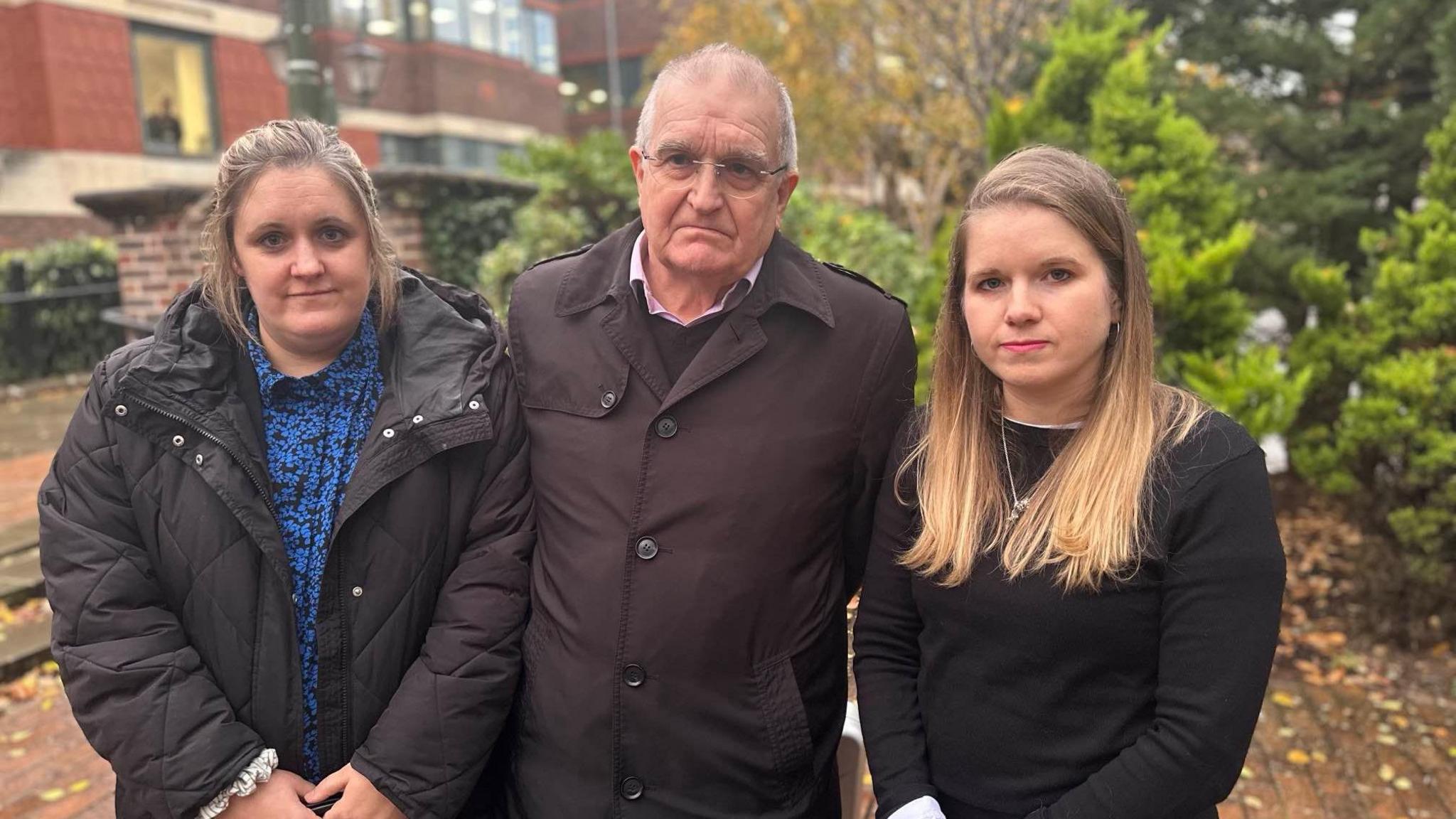 Wanda Clement, Graham Pearce and Dr Holly-Joy Sutton standing side by side with trees and buildings behind them